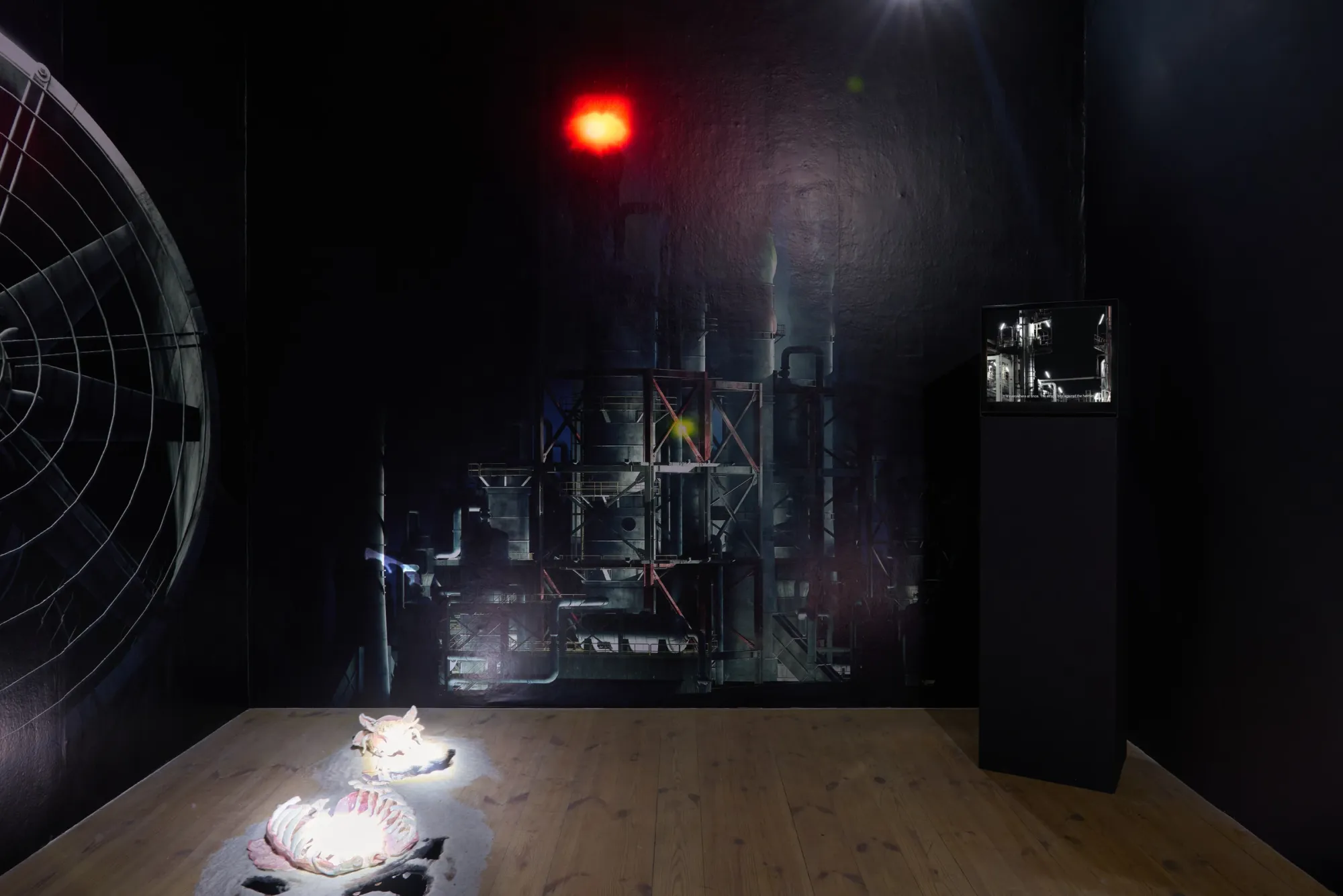 Anna Engelhardt and Tina Bxtq, Bleed Through, Galerie 35M2, Prague, 2026, room view with two ceramic objects on floor and red light overhead