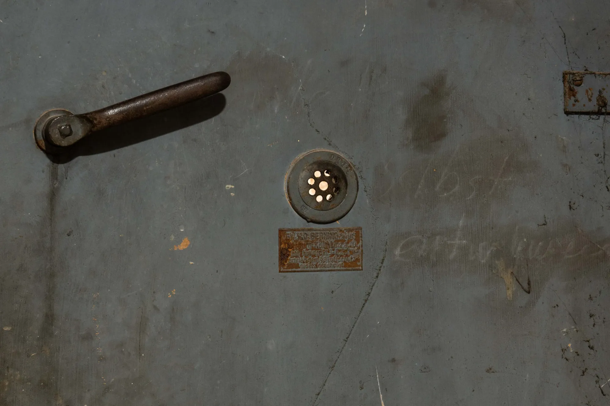 Joschua Yesni Arnaut, ungerne, Galerie 3AP, Frankfurt, 2026, close-up of aged metal door surface with scratched text and hardware