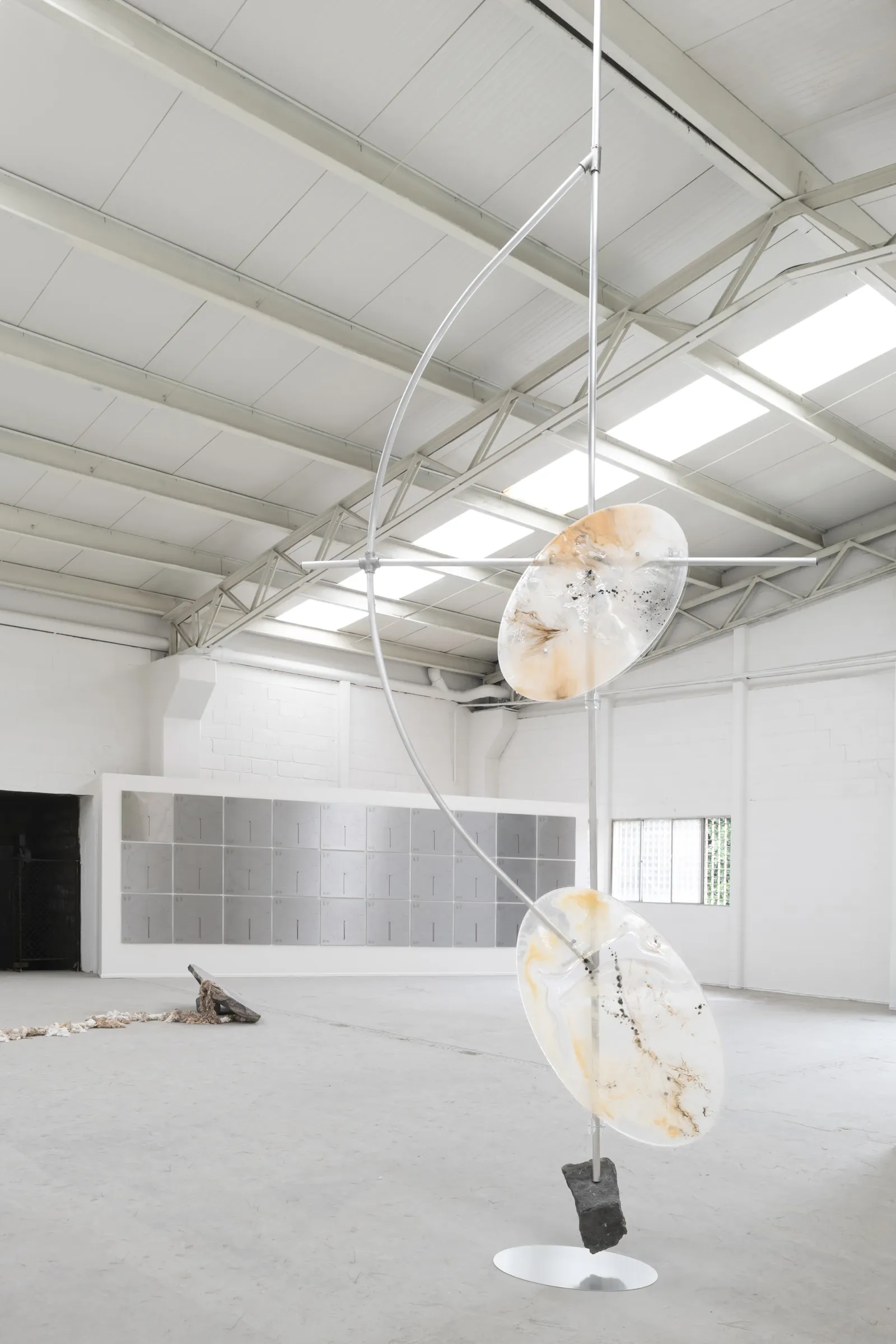 Sara Kieffer & Lucien Woodtli KiefferWoodtli, AXES, Alvarez Chida, Mexico City, 2026, Pendulum sculpture with heliosPlates grid wall in background