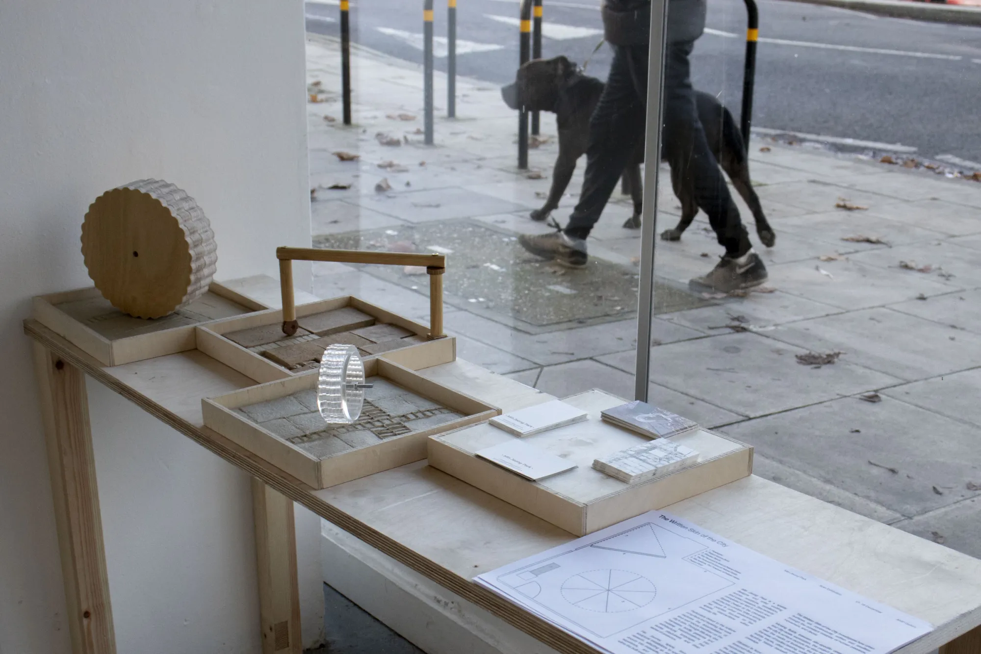 Min Jeong Park, Prototypes for the Wheeled Bench, wooden frames with reclaimed pavement tiles, AMP Gallery, Peckham street visible outside, 2025