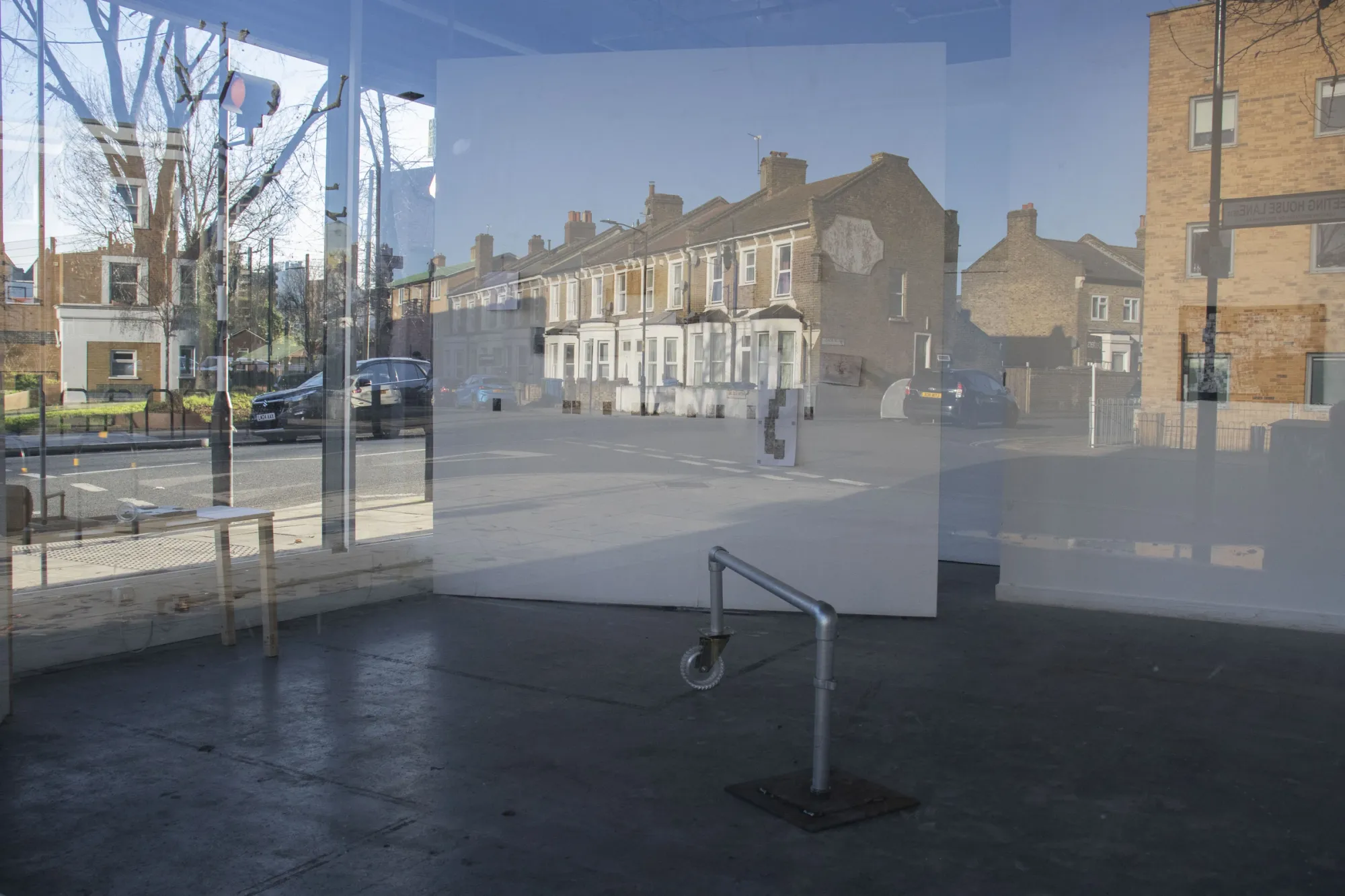 Min Jeong Park, The Written Skin of the City, view through glass facade, Wheeled Bench visible inside, AMP Gallery Peckham, 2025