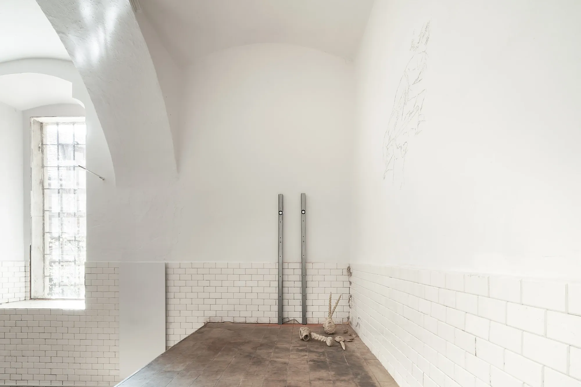 Anzhelika Palyvoda, Echoes that refuse to fade, FAVU Gallery Brno, 2026, two vertical metal profiles against tiled wall with Struger ceramics on floor and wall drawingfallback