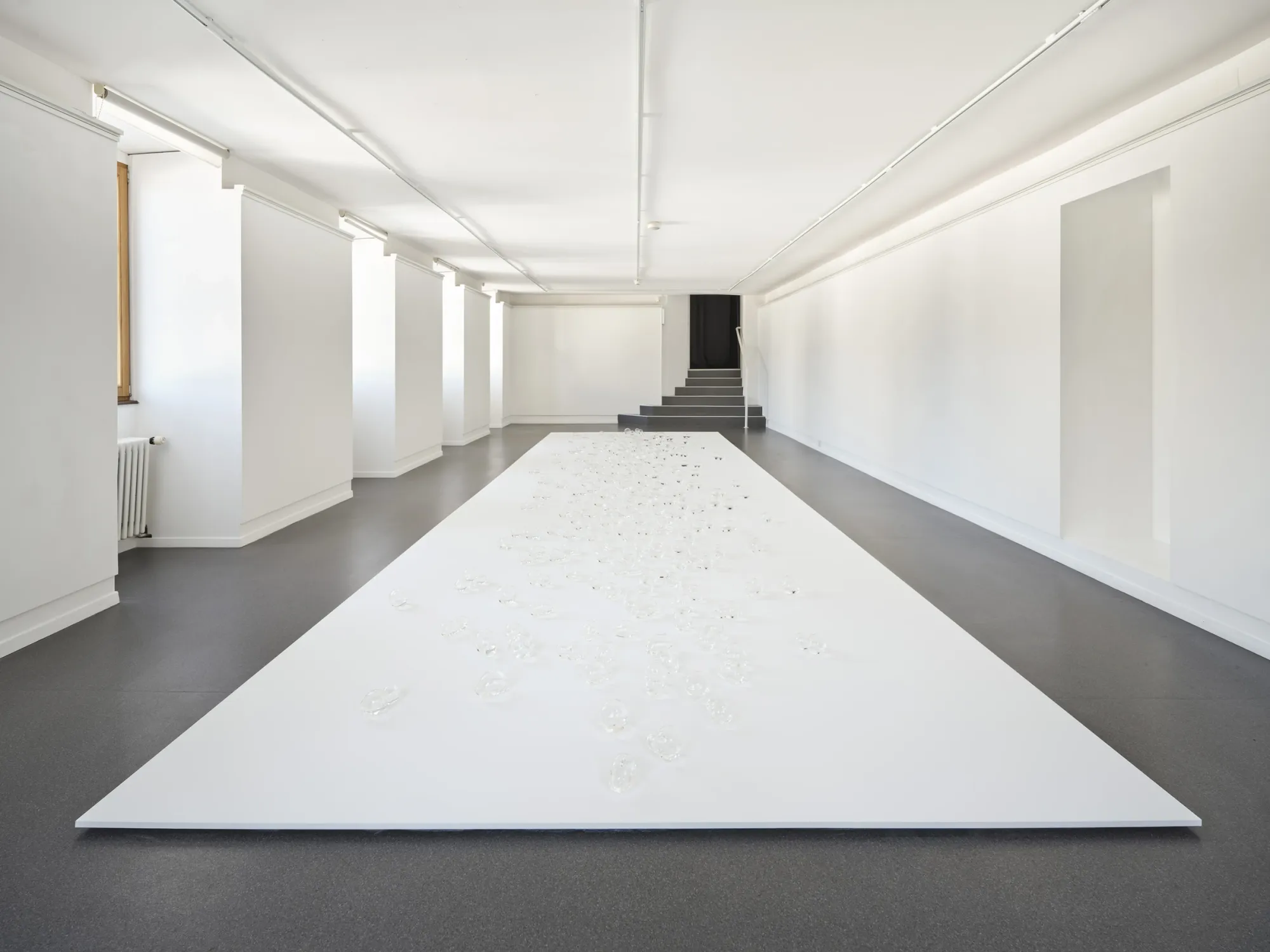 Rahel Oberhummer, Plaine Morte, 2025, installation view from gallery entrance, white surface with glass bubbles, Montreux