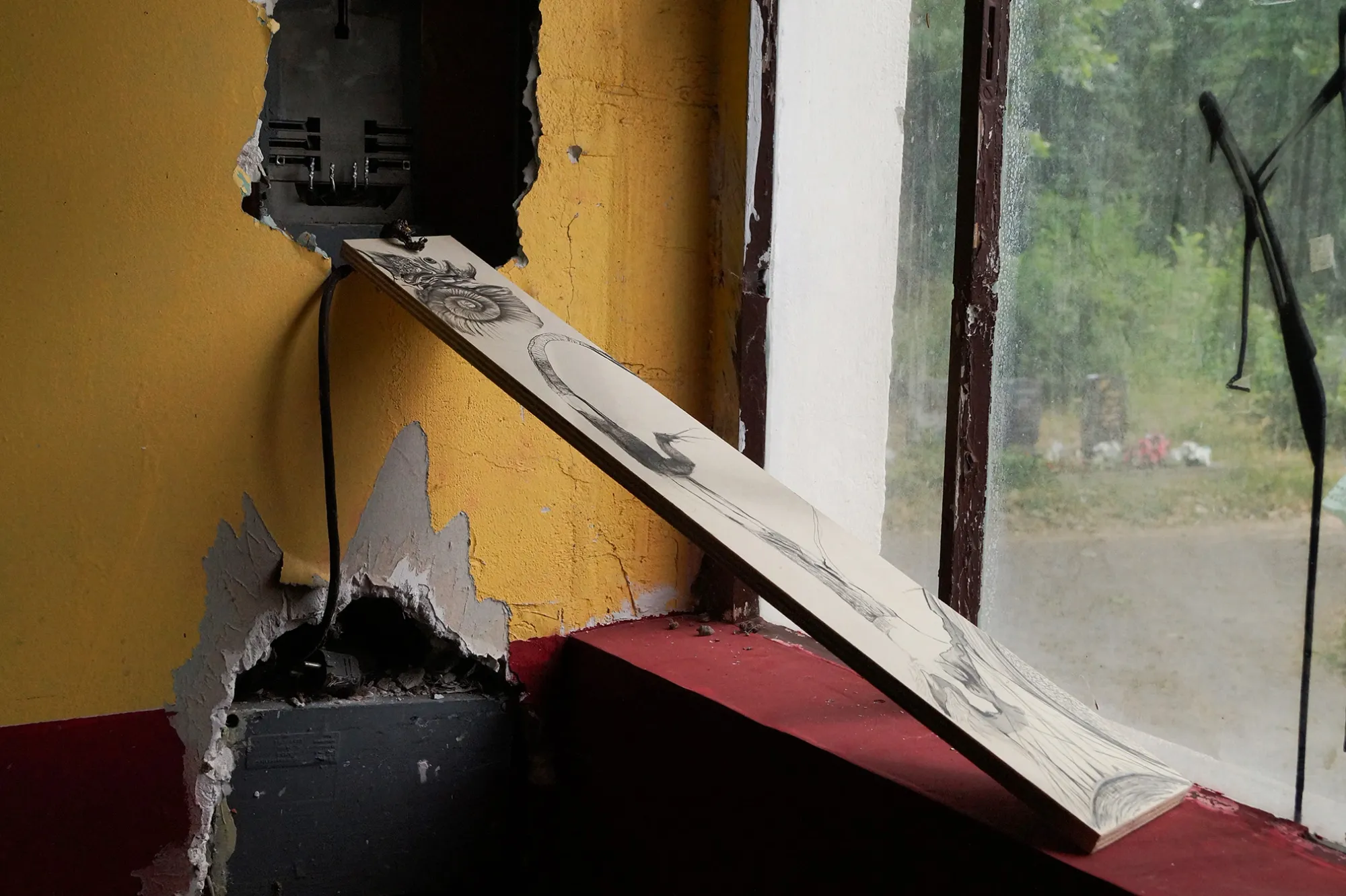 Matilde Sambo, Chapter II, Phantom Pförtnerhaus, Berlin, 2026, graphite drawing on board leaning against crumbling yellow wall at cemetery window