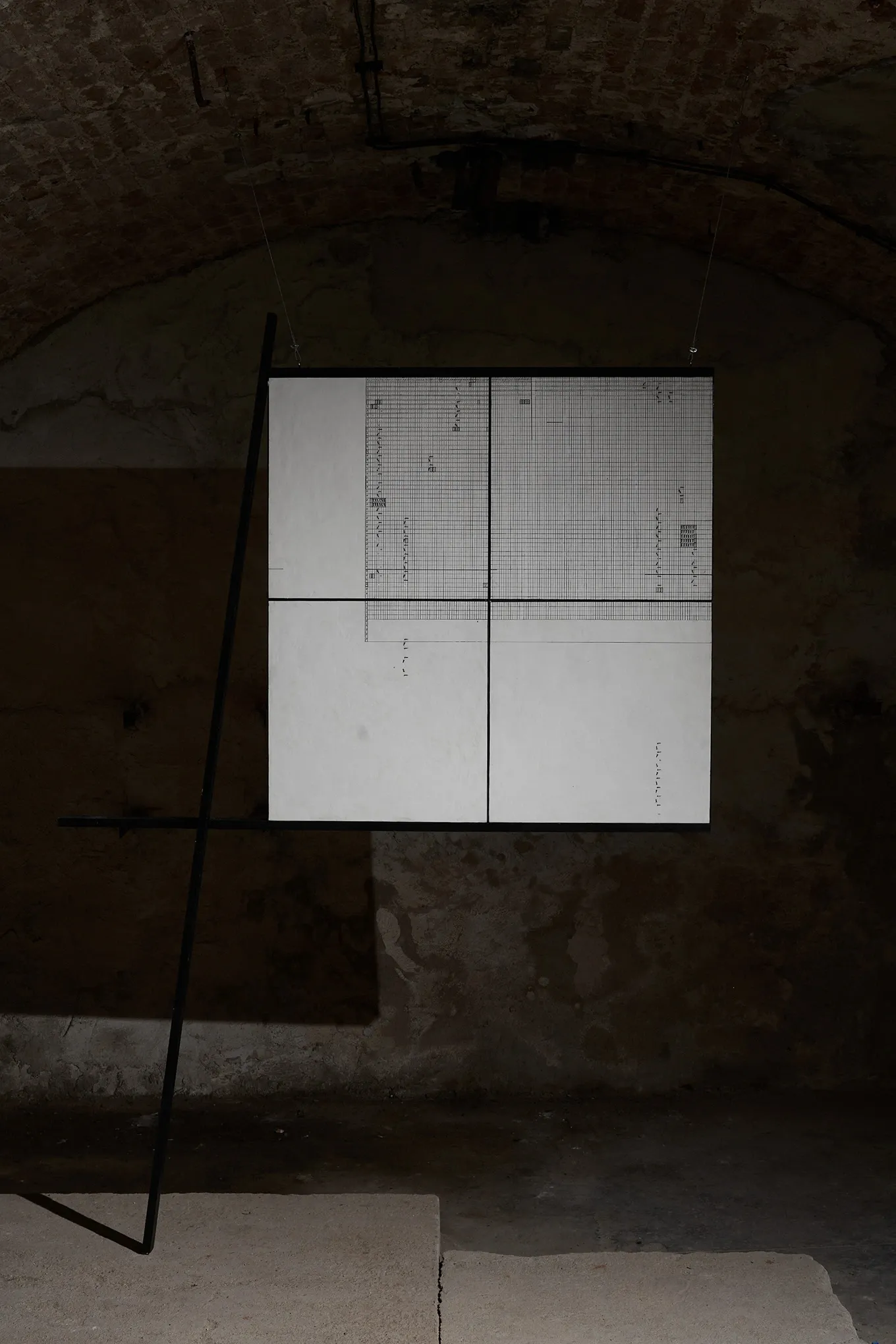 Sofiia Yesakova, Echoes that refuse to fade, FAVU Gallery Brno, 2026, grid document suspended in vaulted basement with metal frame