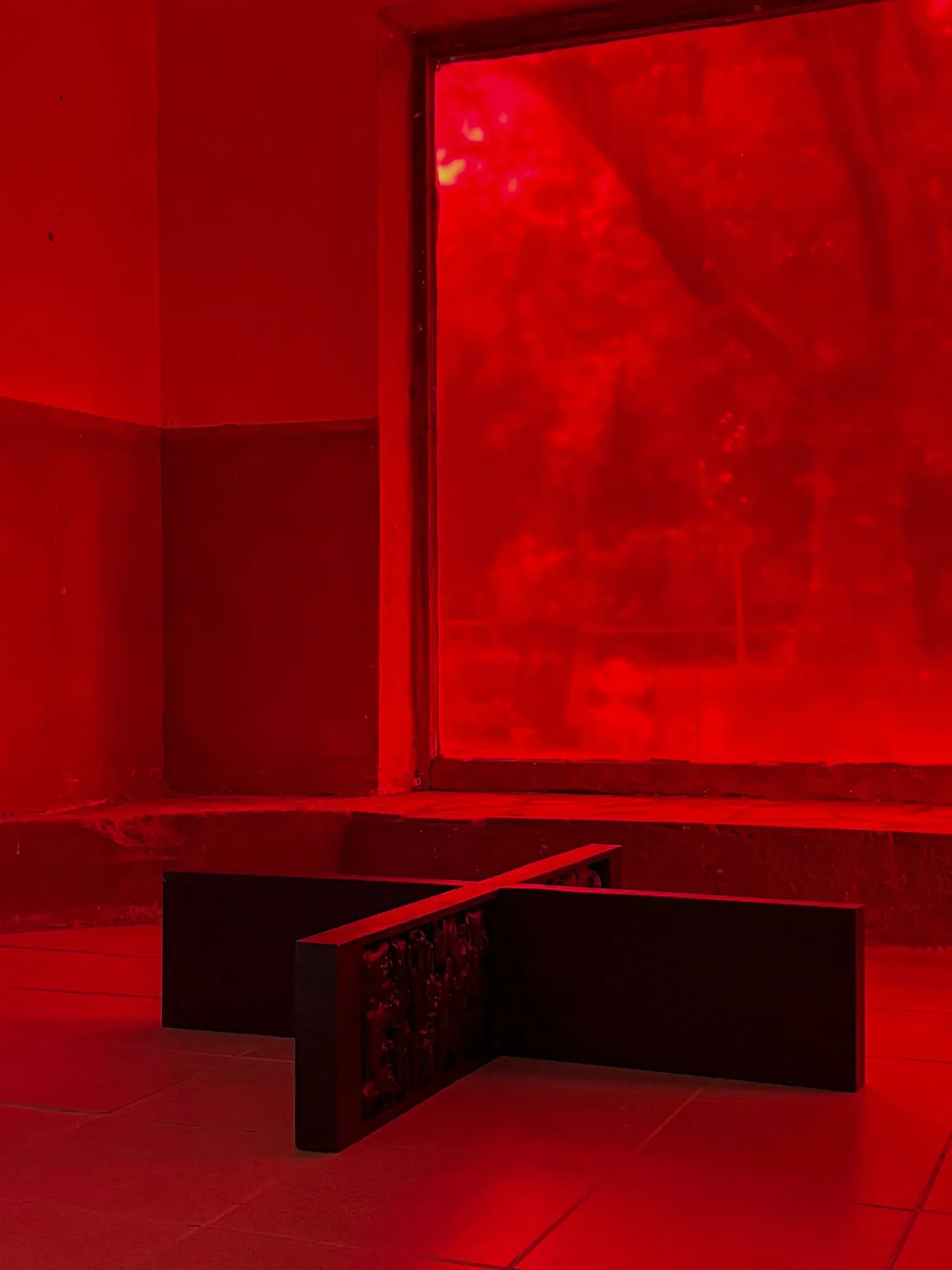 Sofiia Yesakova, Ugly Scenes. Nuances 4.1., Phantom Pförtnerhaus, Berlin, 2026, black wood cross-form sculpture with carved surface in red-lit space