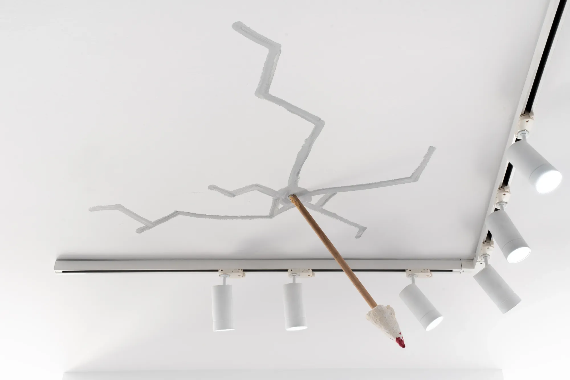 Yeti, wooden stick propped against ceiling lighting rail with branching grey tree painted on white ceiling, The Edit Gallery, Limassol, 2026