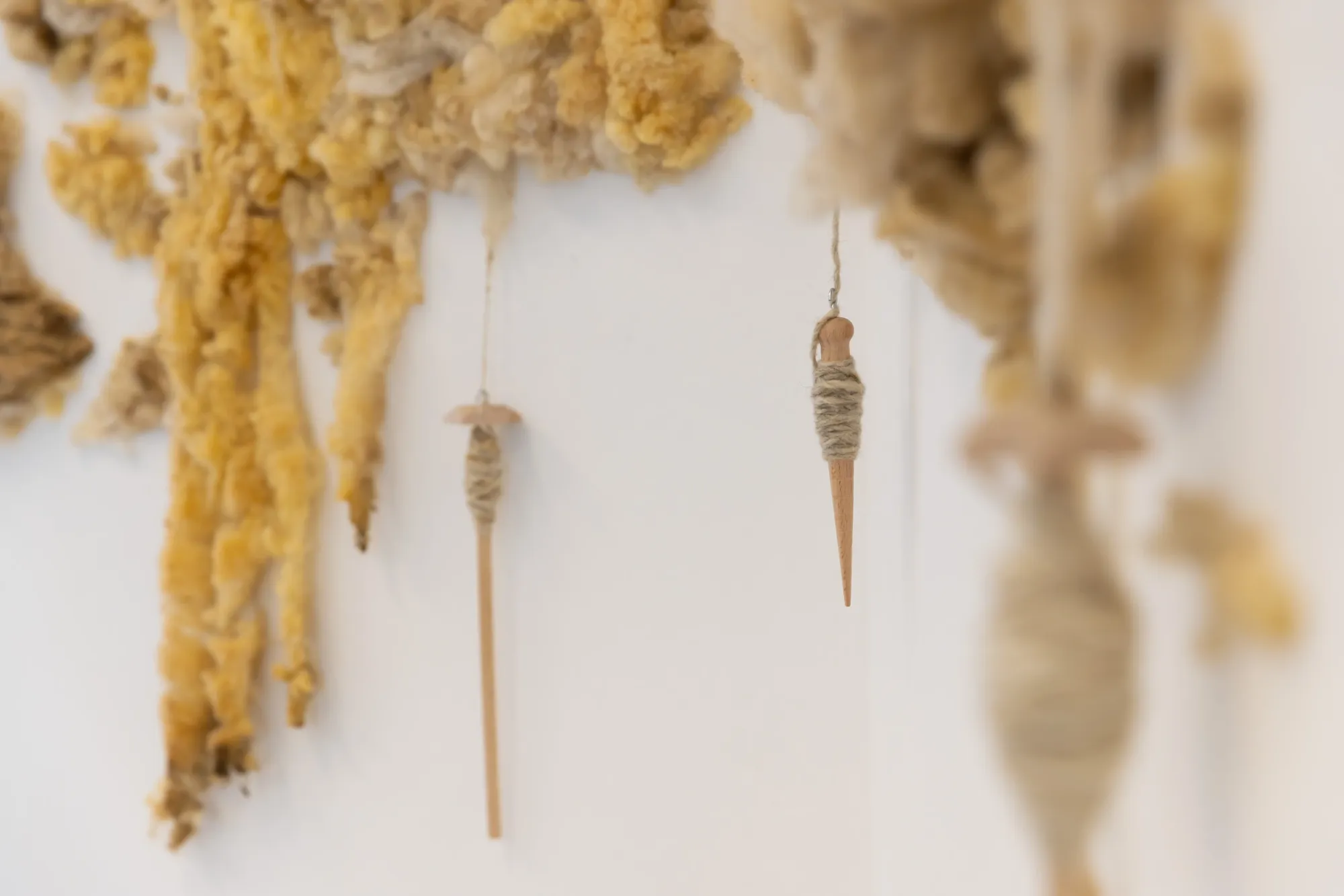 Aliz Farkas, A Parable for Endings and Beginnings, rotor, Graz, 2026, detail of hand spindles hanging from wool installation