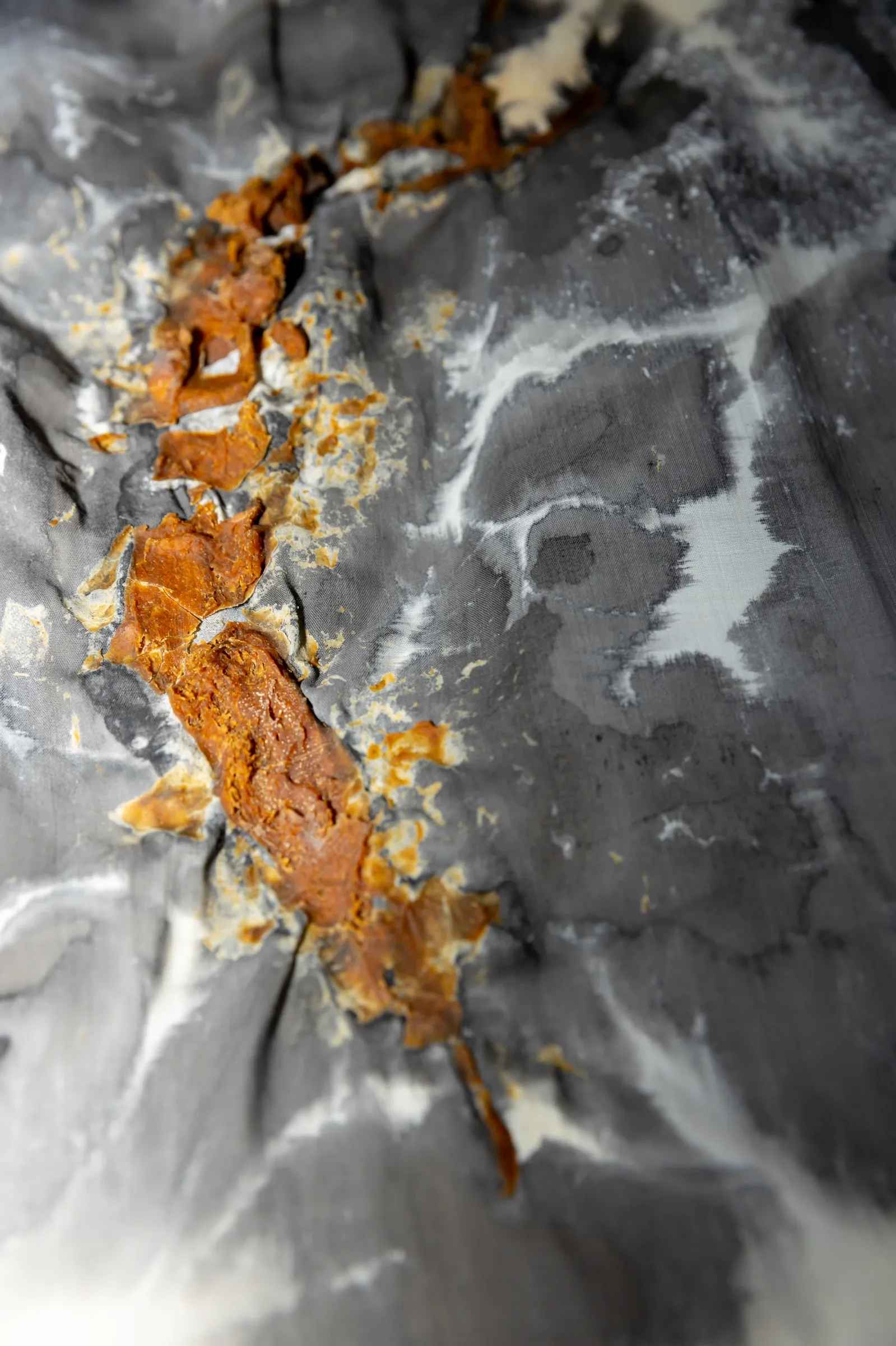 Exhibition review of Despina Charitonidi, close-up detail showing barnacled ceramic texture with rust stains and water droplets.