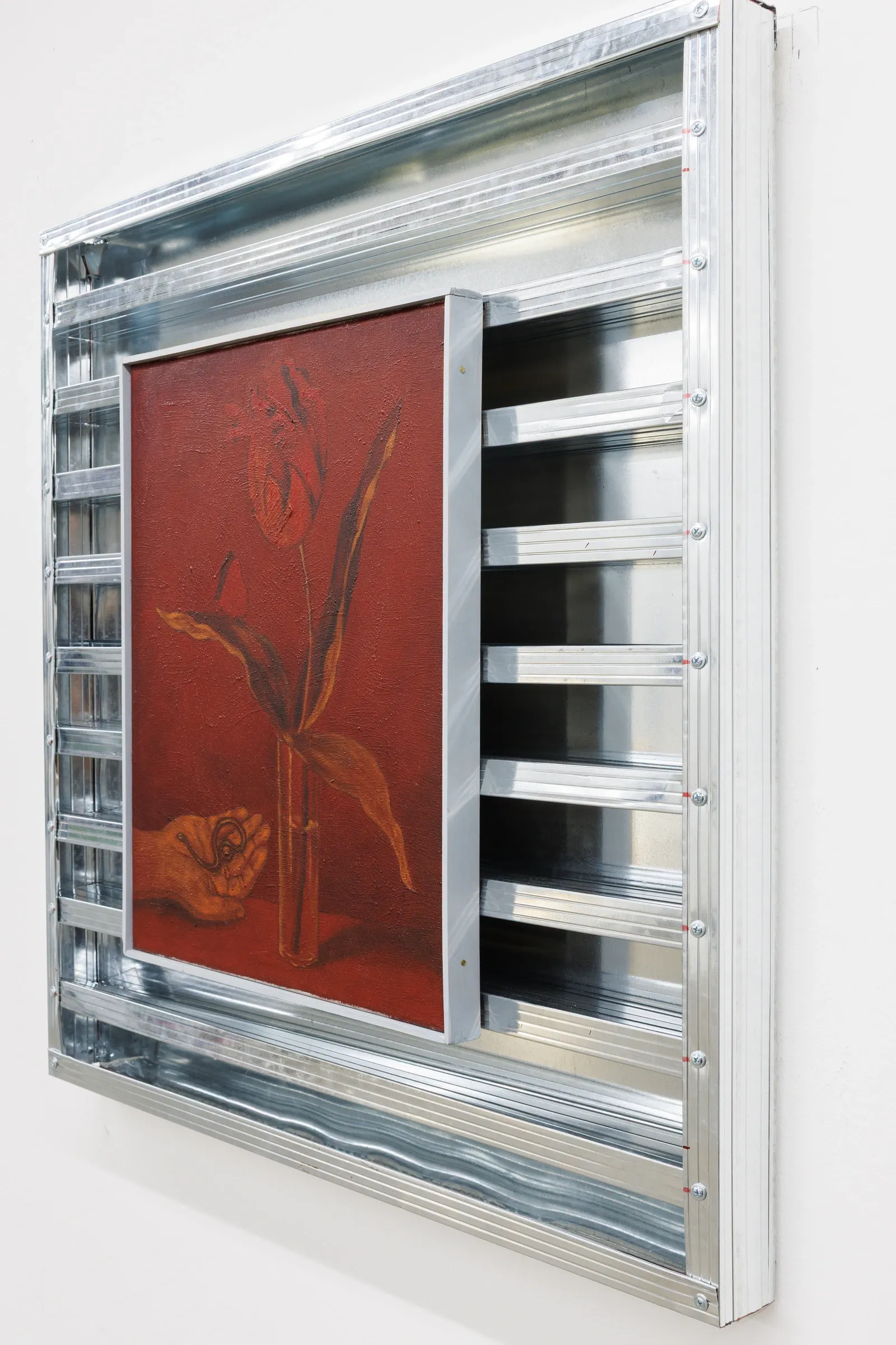 Exhibition review of Erekle Chinchilakashvili: The Story of a Thread Seen From the Window at The Why Not Gallery, Tbilisi, 2026, detail, angled close-up of a red painting with a hand and floral motif, seen through the steel grid rails.