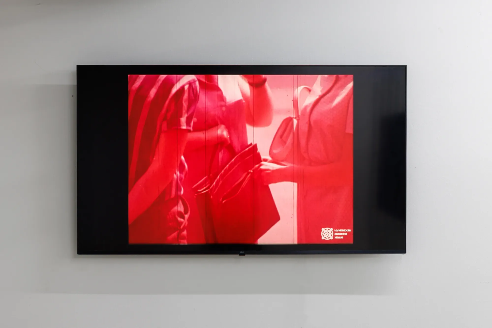 Exhibition review of Erekle Chinchilakashvili: The Story of a Thread Seen From the Window at The Why Not Gallery, Tbilisi, 2026, detail, wall-mounted screen showing a saturated red archival video still from the exhibition's video essay.