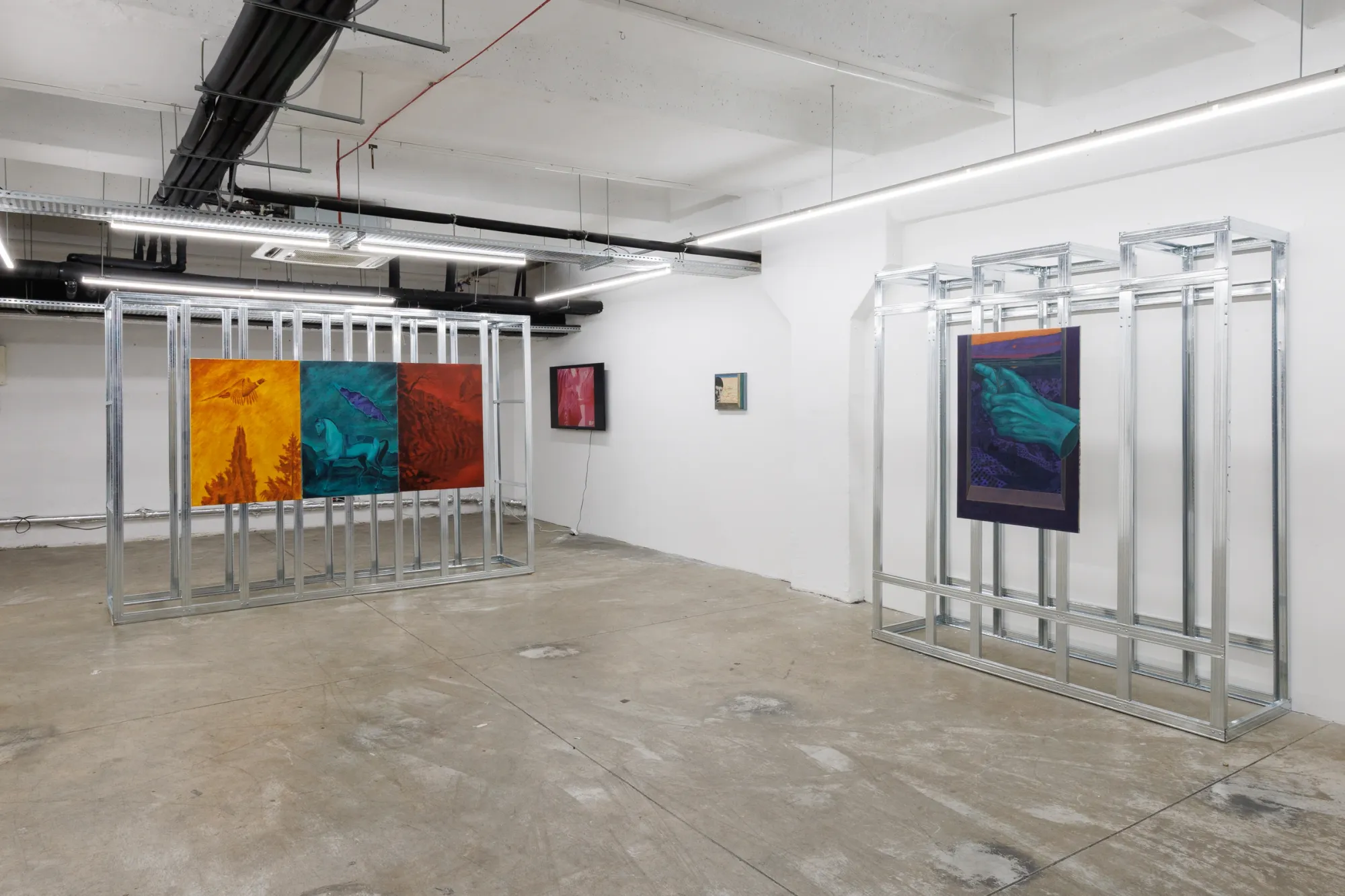 Exhibition review of Erekle Chinchilakashvili: The Story of a Thread Seen From the Window at The Why Not Gallery, Tbilisi, 2026, installation view, frontal view of a red, teal and purple painted triptych hanging inside a raw aluminum grid frame.