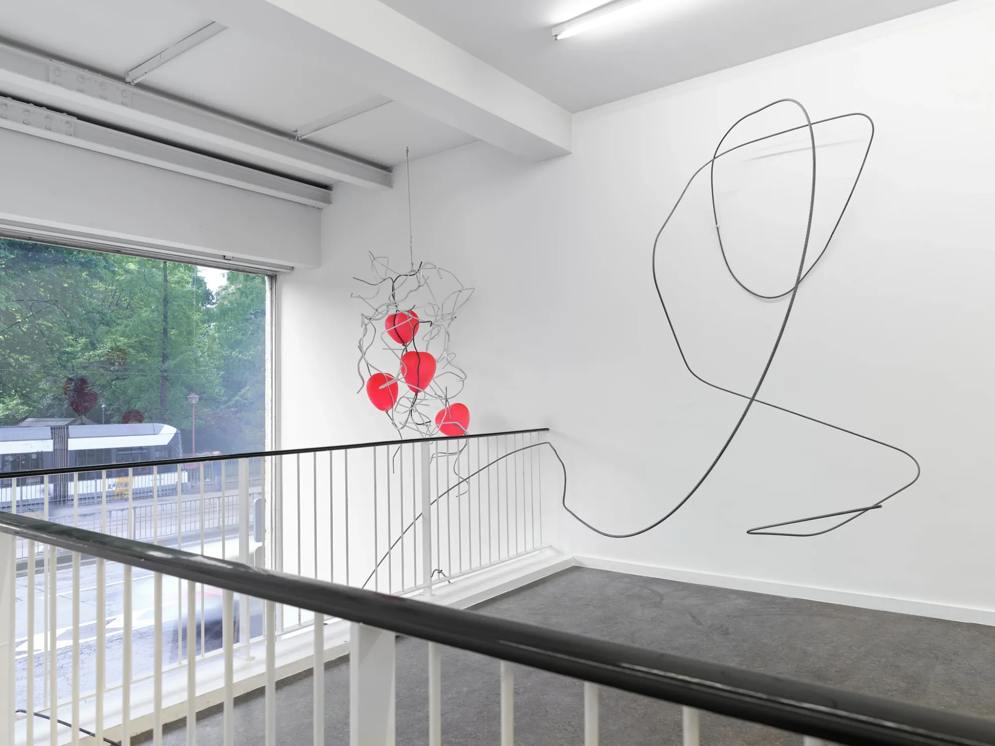 Hannah Perry, Hard Love, Tick Tack, Antwerp, 2026, stairwell with looping wire wall piece and hanging red sculpture
