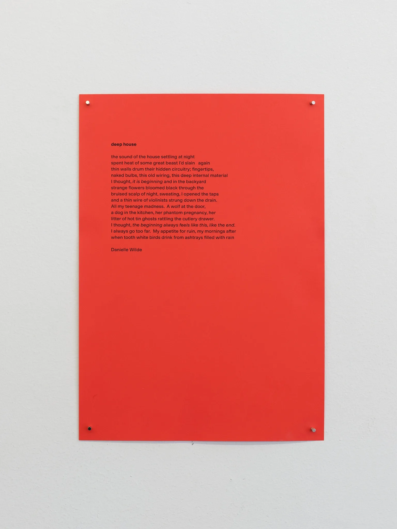 Poem "deep house" by Danielle Wilde printed on red paper, installed at Tick Tack for Hard Love, 2026