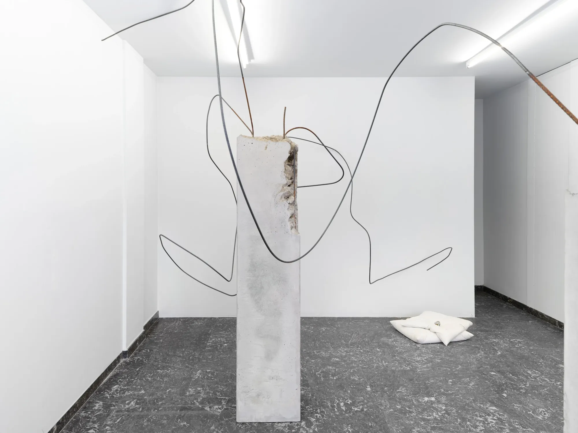 Hannah Perry, Hard Love, Tick Tack, Antwerp, 2026, broken concrete slab with exposed rebar and a soft white pillow form