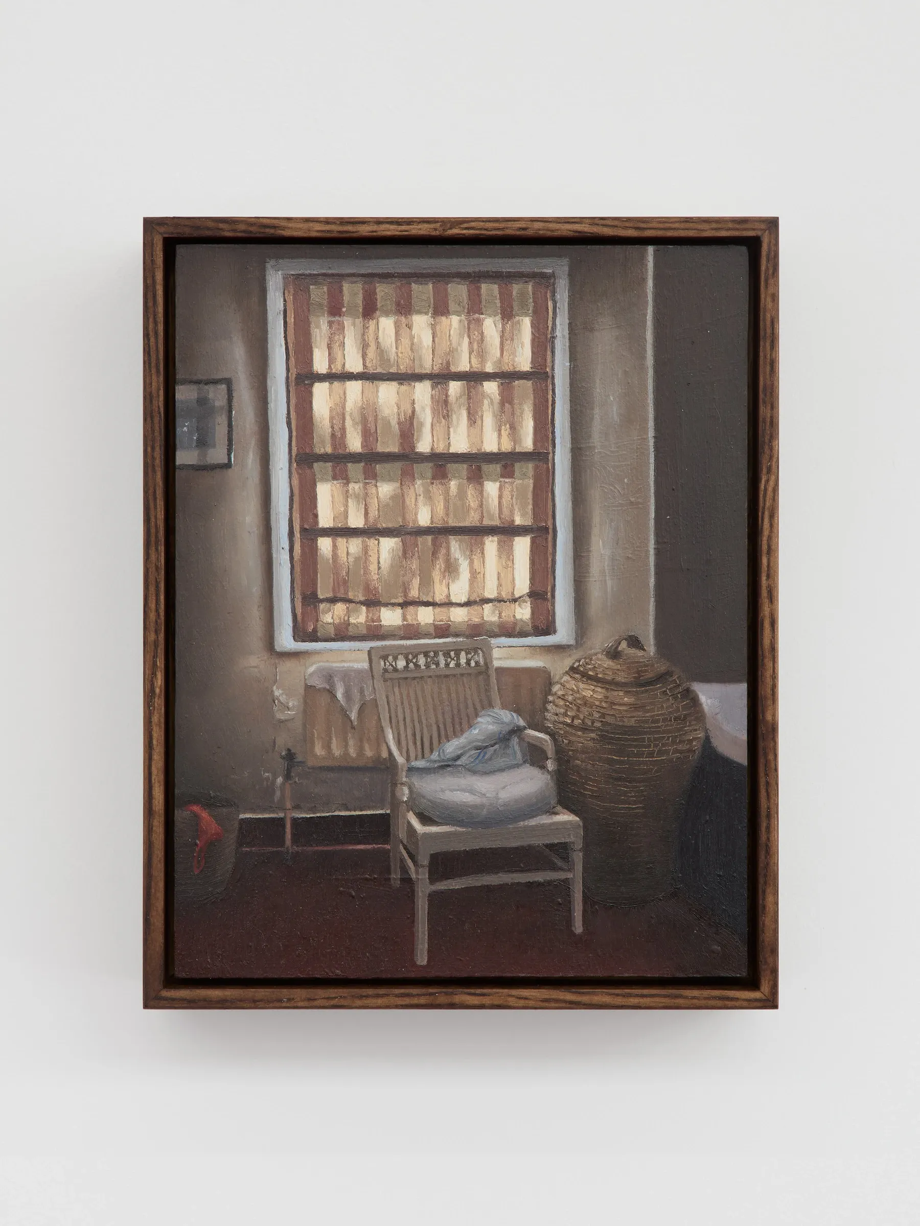 Selena Corsellis Exhibition review of What Shall We Do for the Rent? at Haricot Gallery, London, 2026. Dim domestic interior, striped window blind, wicker chair and basket in warm brown light.