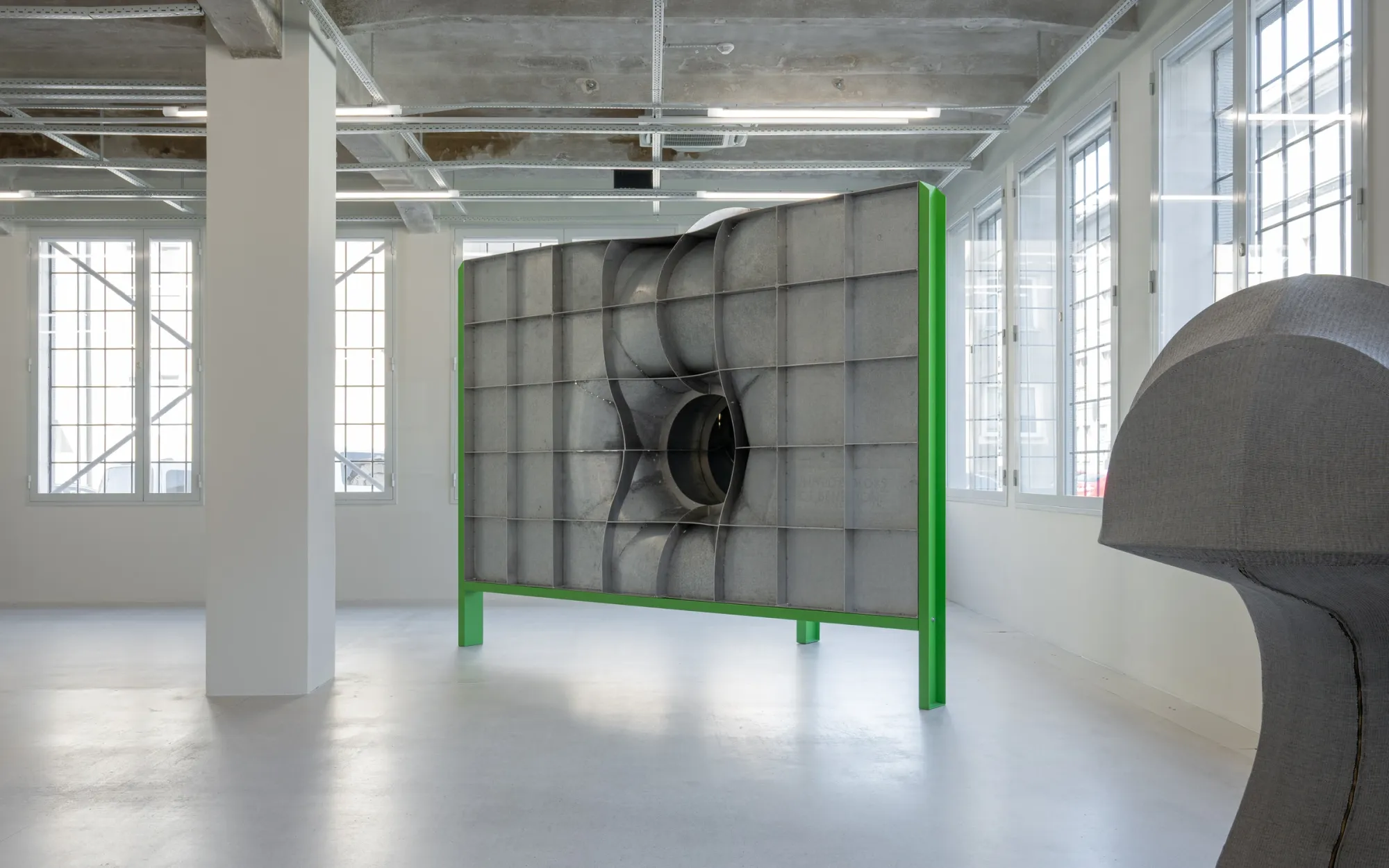 Exhibition review of Jiří Příhoda: Signal V at Telegraph Gallery, Olomouc, 2026. Weathered grey metal panels folding around a dark circular tunnel opening.
