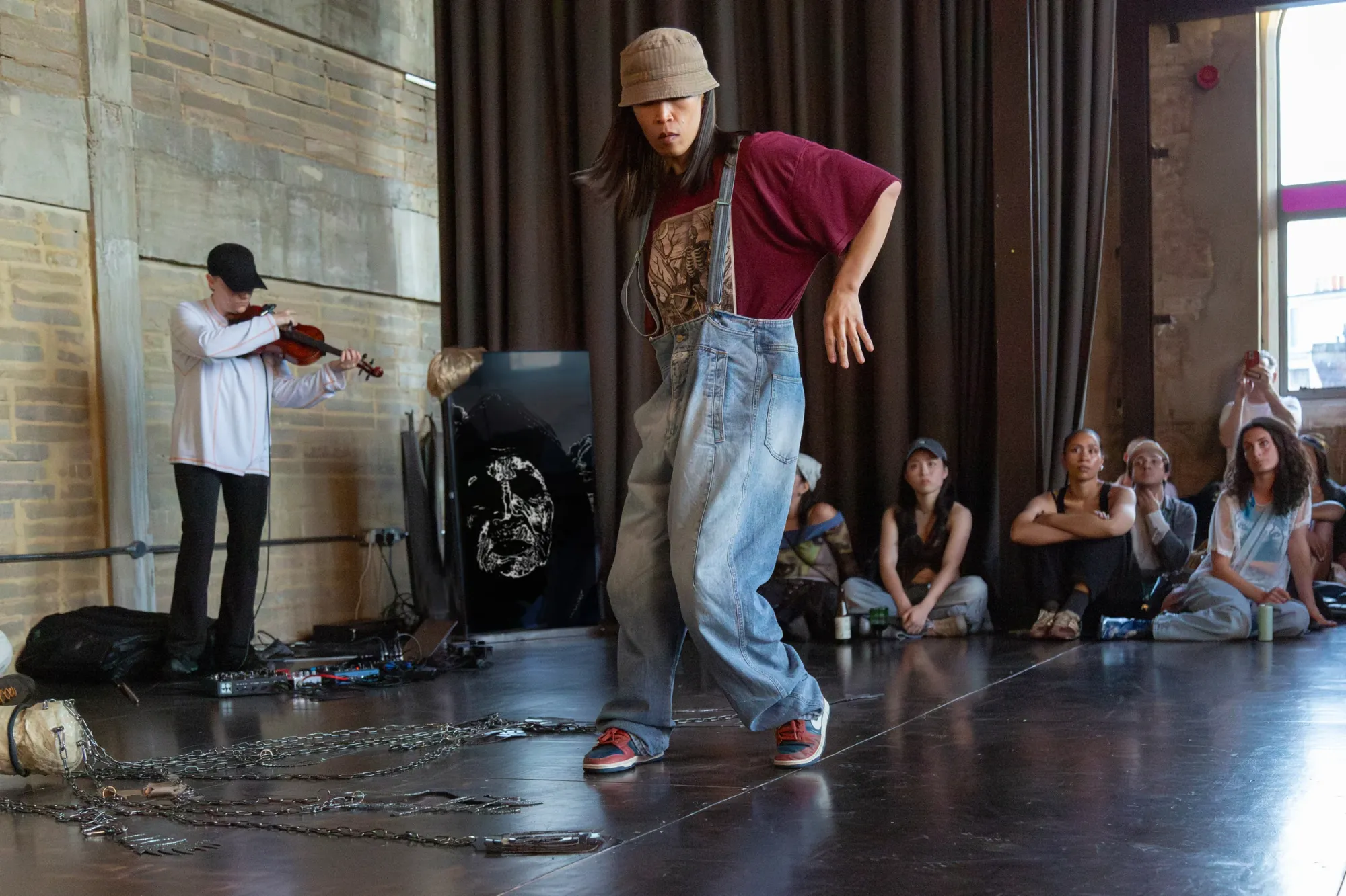 Nicola Genovese, Infinite Stage, Raleigh Chapel, London, 2026, dancer and violinist performing before a seated audience and video screen