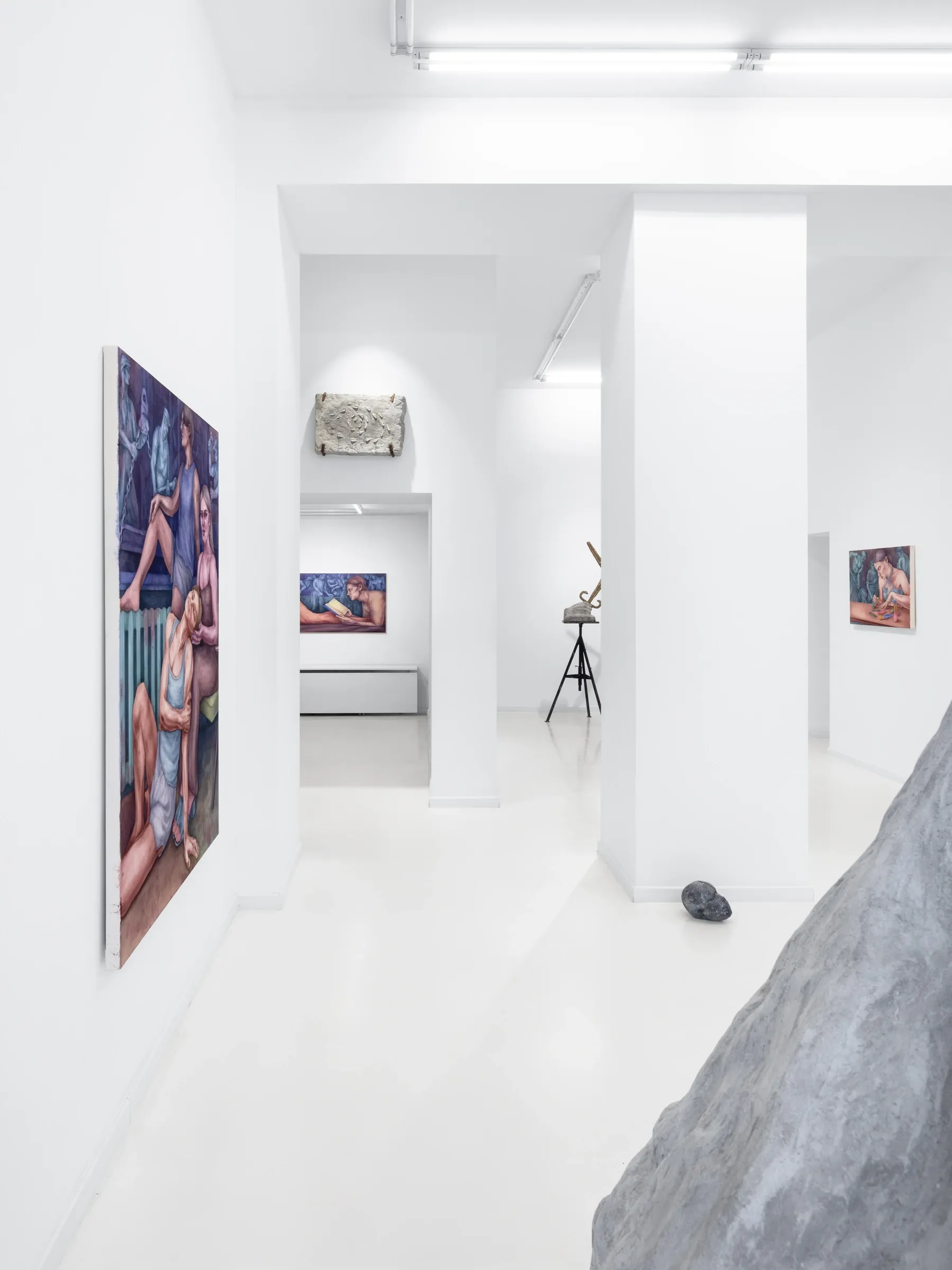 Maciej Nowacki and Miłosz Tomkowicz, Blood Concrete Sun, HOS Gallery, Warsaw, 2026, corridor view with a stone relief and a bronze sword sculpture on stands