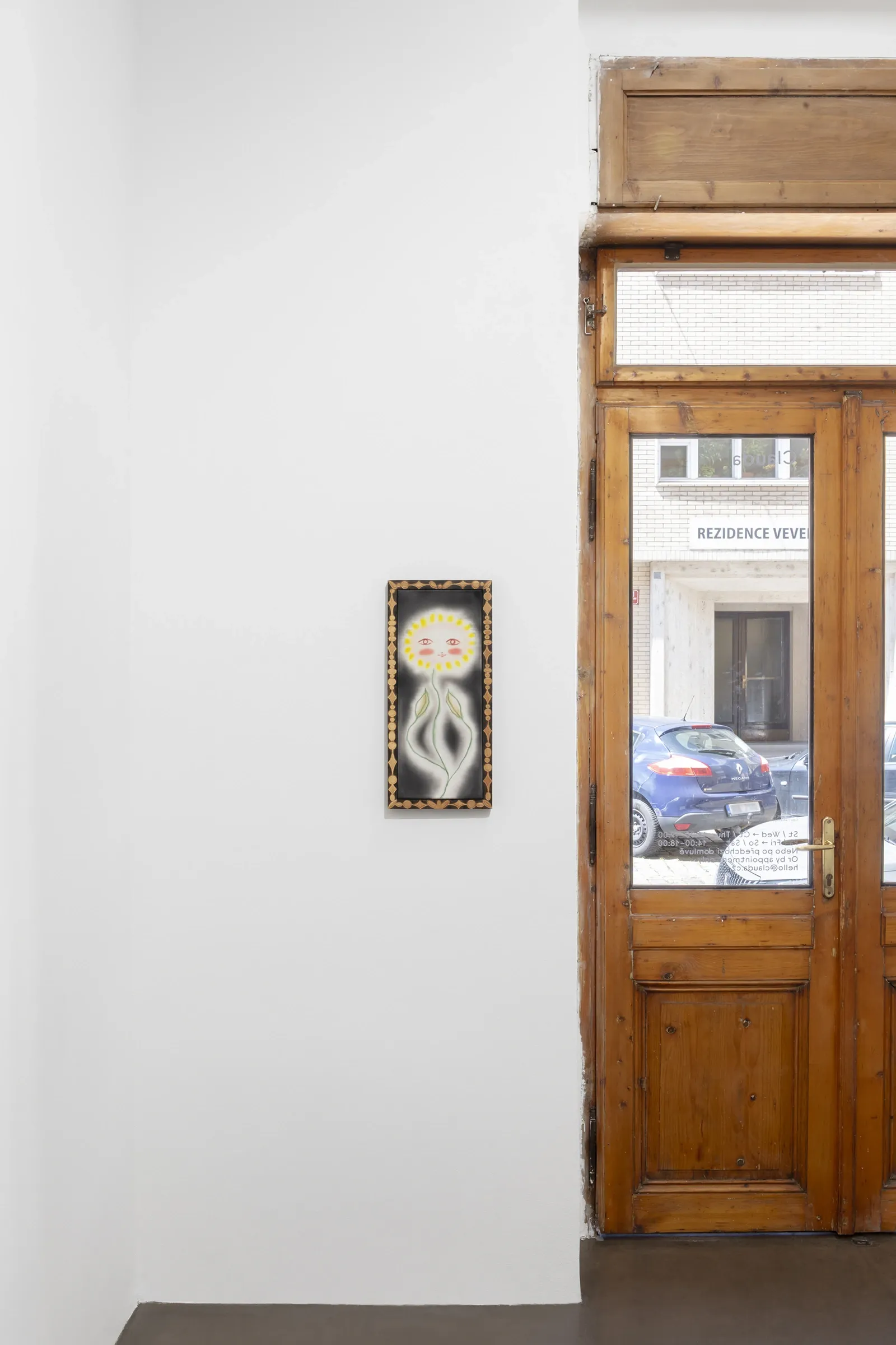 Olga Krykun, Stardust for Tomorrow, Clauda, Prague, 2026, sunflower face on black ground in a carved wood frame