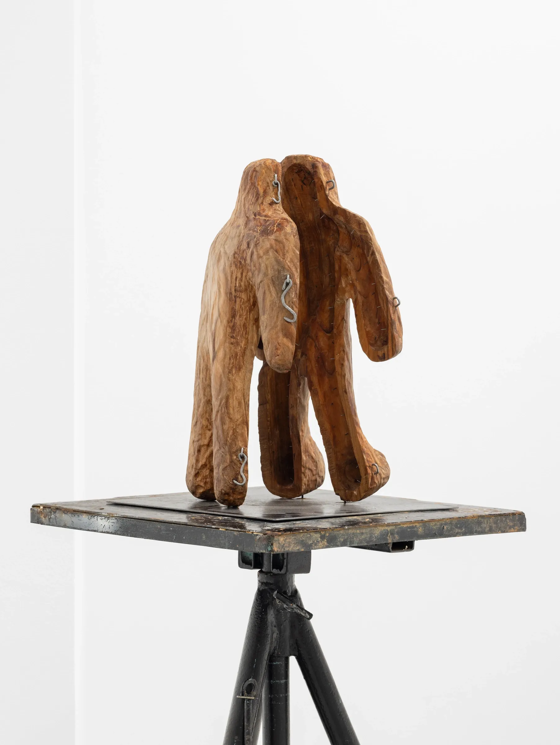 Miłosz Tomkowicz, Casing for a lost soul, HOS Gallery, Warsaw, 2025, two joined carved wood hooded forms with metal hooks
