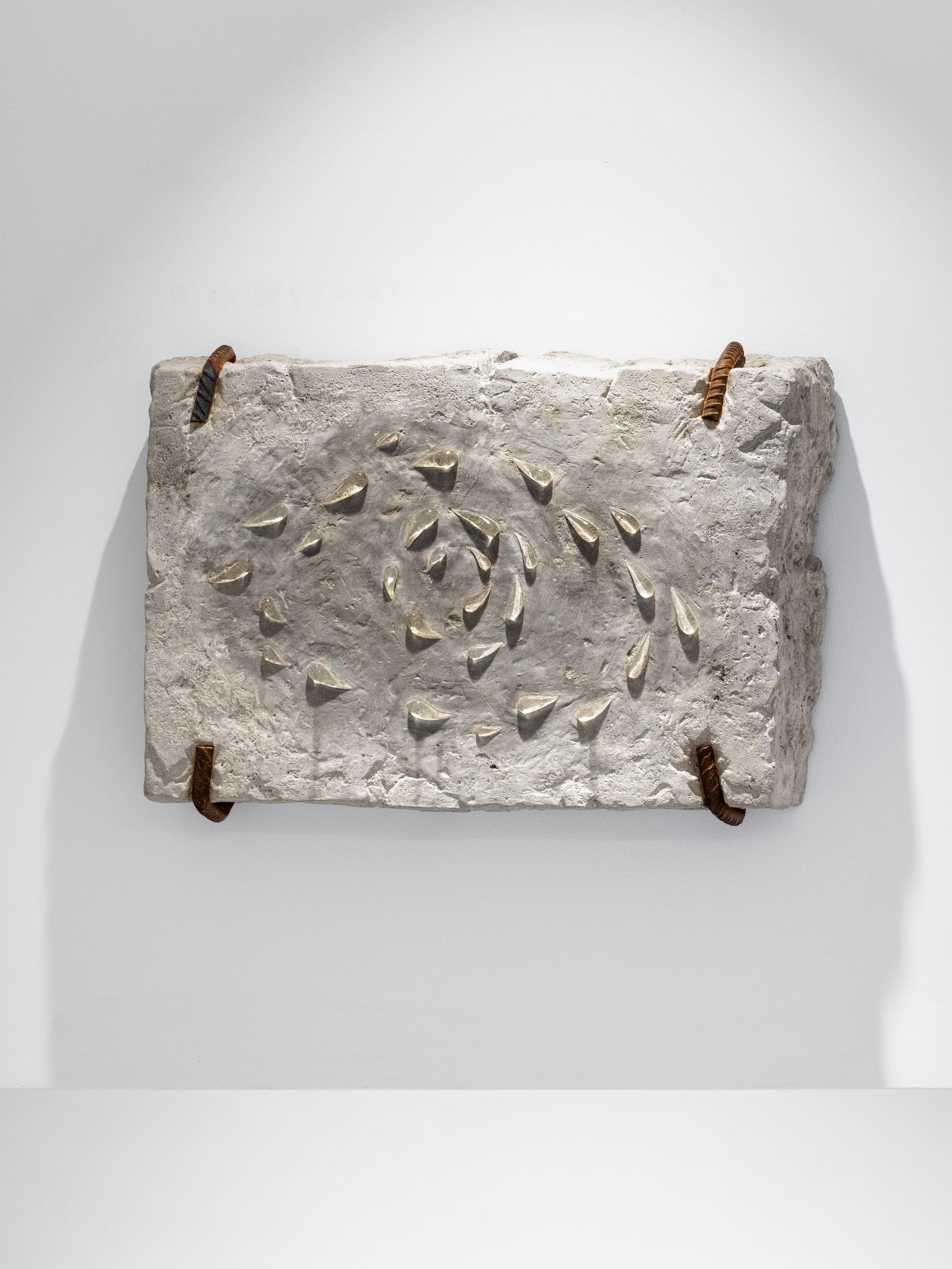 Miłosz Tomkowicz, Vortex, HOS Gallery, Warsaw, 2024, concrete wall relief with a spiral of small metallic teardrop forms
