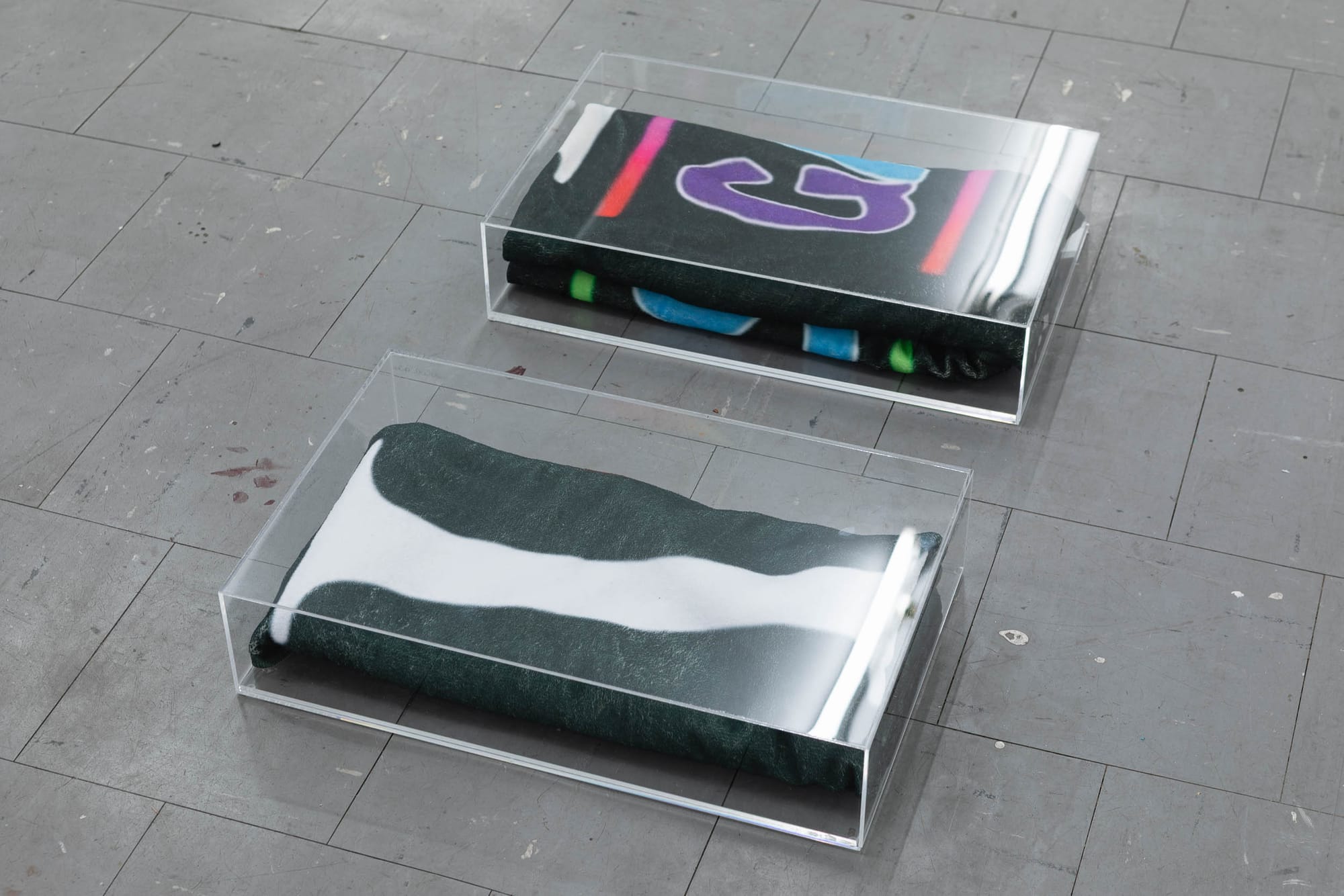 Ville Laurinkoski, Object of Devotion, Skånes konstförening, Malmö, 2026, detail of printed fabric in acrylic display boxes