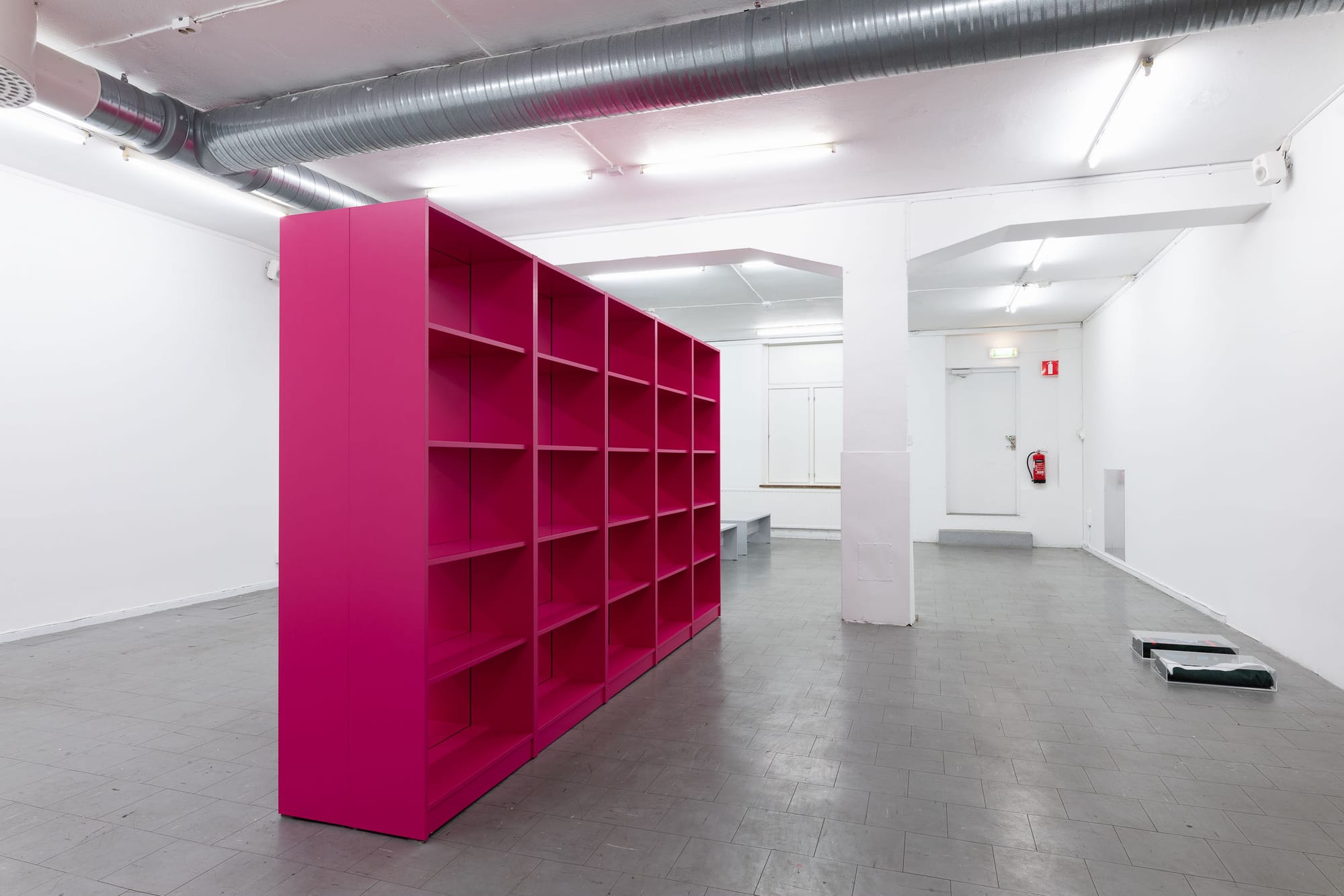Ville Laurinkoski, Object of Devotion, Skånes konstförening, Malmö, 2026, magenta bookshelf and benches in gallery