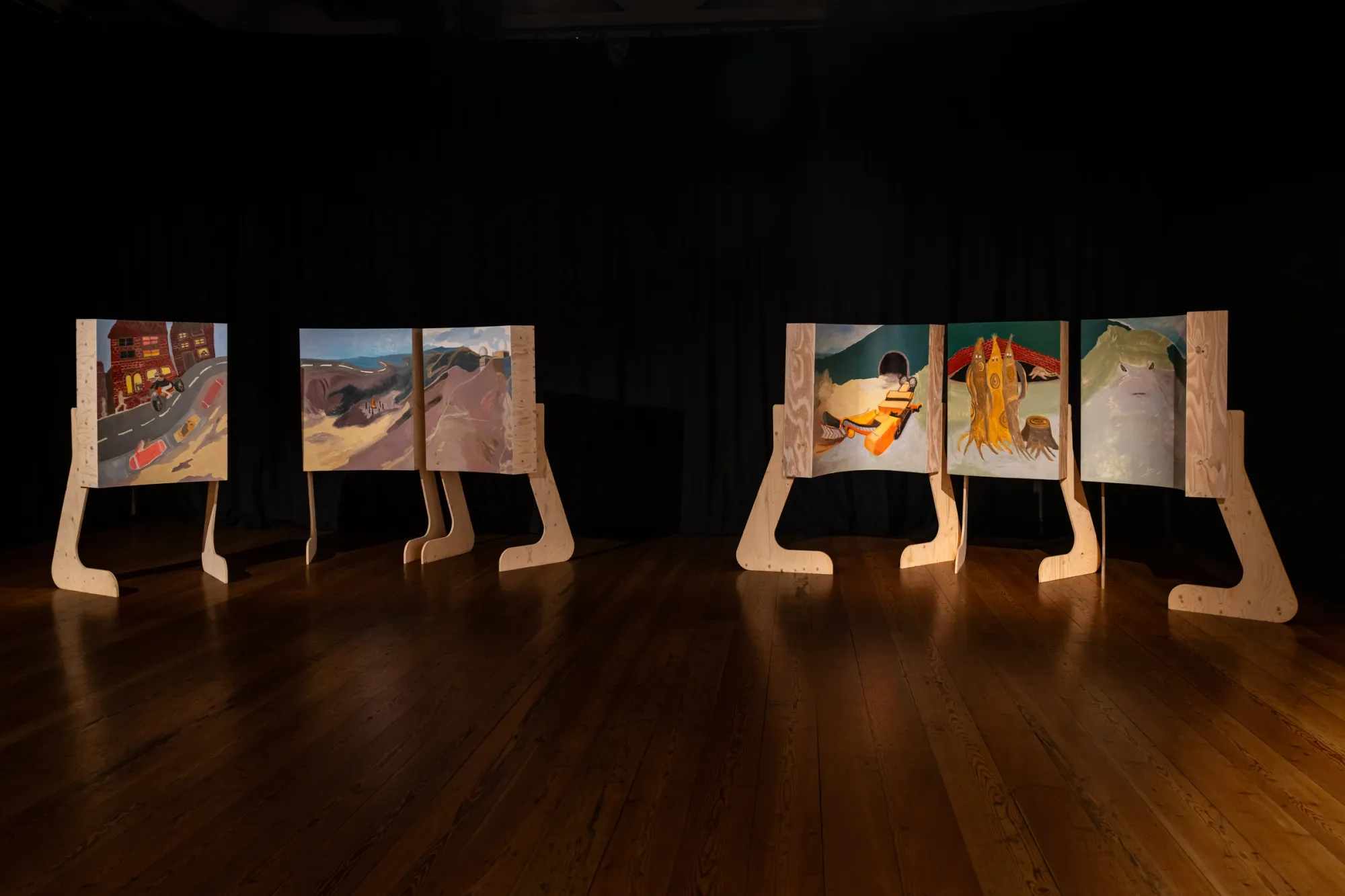 Katrin Plavčak instalalton view transfer StyriaExhibition review of Katrin Plavčak: TRANSFER at Kulturforum Laßnitzhaus, Deutschlandsberg, 2026. A three-panel painted wooden screen showing a tunnel entrance, standing figures and a mountain face.