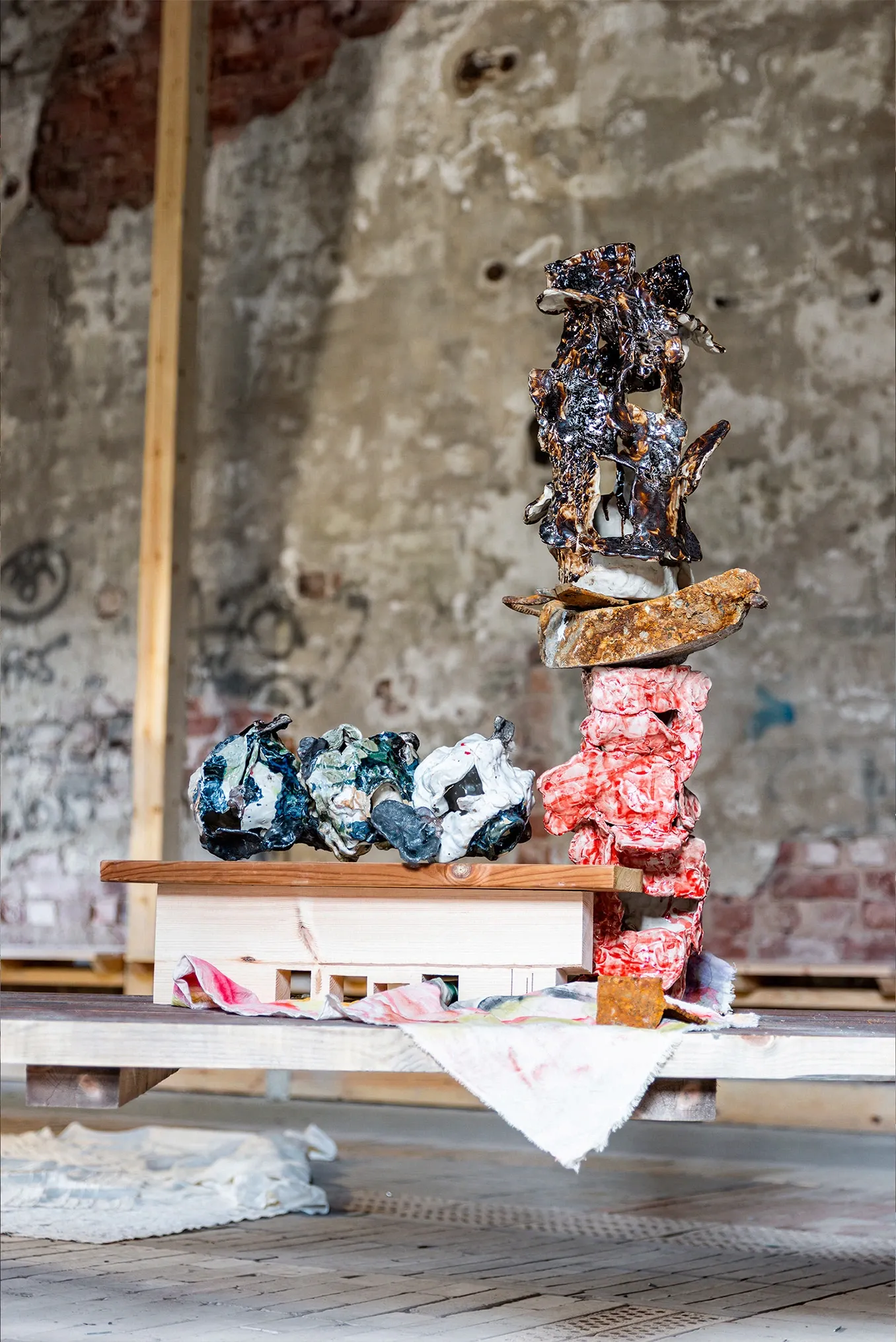 Exhibition review of Dan Kim: White Nights at AaltoSiilo, Oulu, 2026. A charred black ceramic form balanced above rust toned stone and pink clay.