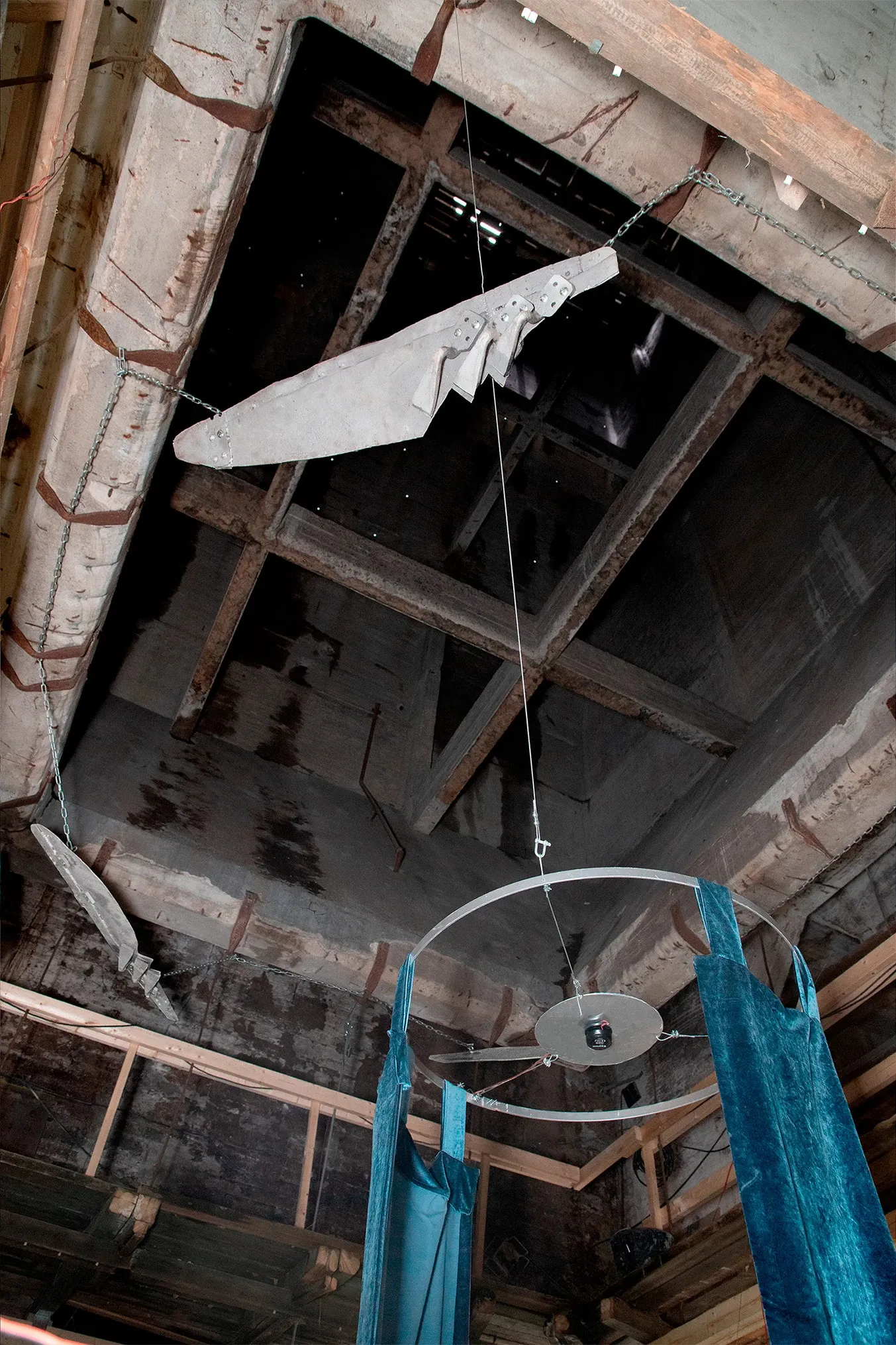 Exhibition review of Jaakko Myyri: White Nights at AaltoSiilo, Oulu, 2026. Sandblasted steel feather forms hanging from wooden roof trusses.