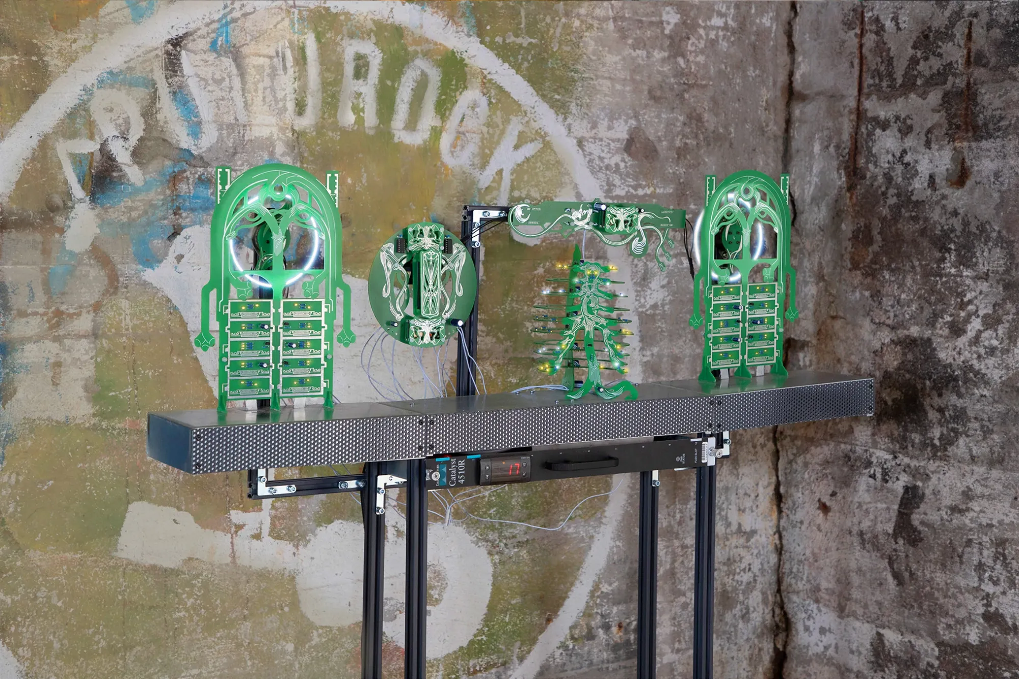 Exhibition review of Jaakko Myyri: White Nights at AaltoSiilo, Oulu, 2026. Green circuit board sculptures resembling ribs and arches on a steel rack.