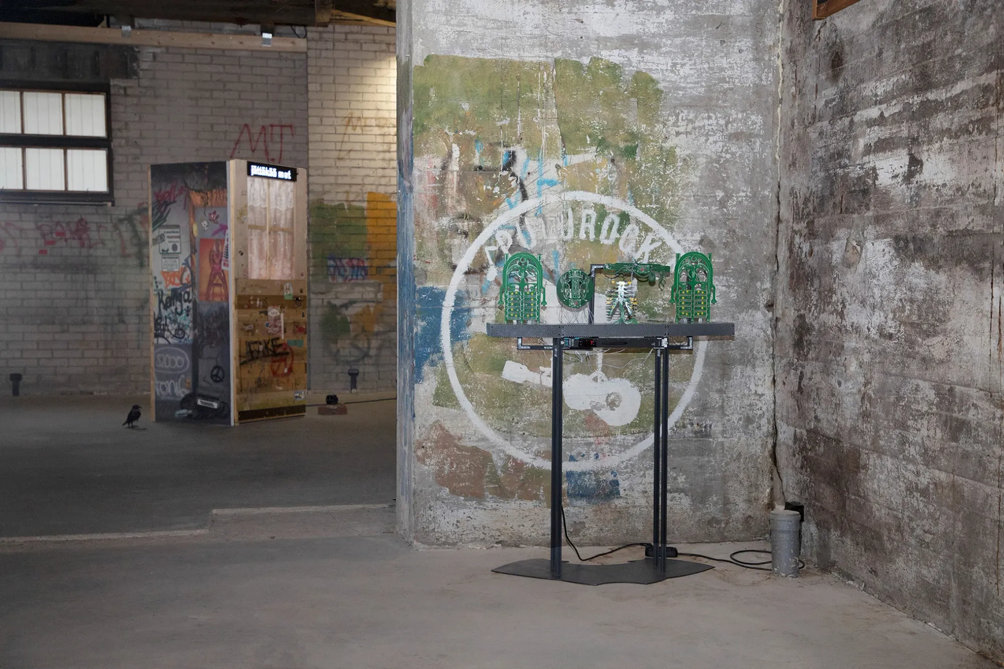 Exhibition review of Jaakko Myyri: White Nights at AaltoSiilo, Oulu, 2026. Circuit board sculpture on a concrete pillar beside a graffiti covered booth.