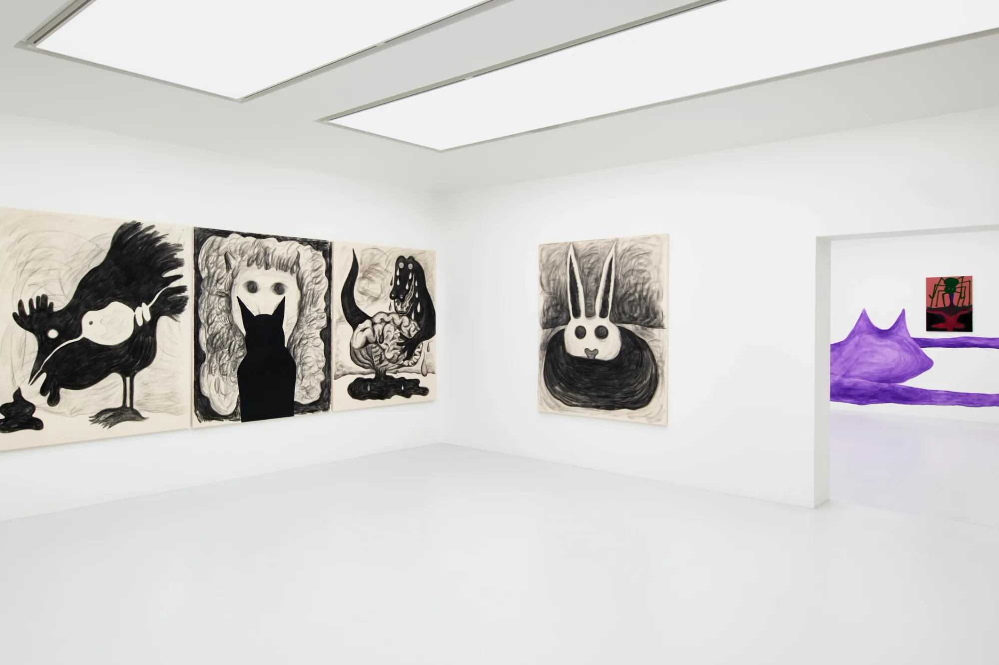 Exhibition review of Kallirroi Ioannidou: Galvanizing Memories at Kallmann-Museum, Ismaning, 2026. Charcoal drawings of a dripping faucet, an animal hanging upside down, a magpie pecking at the ground, a furry face with a black cat silhouette in front of it, and a crouched hare, with a purple mural visible through a doorway.