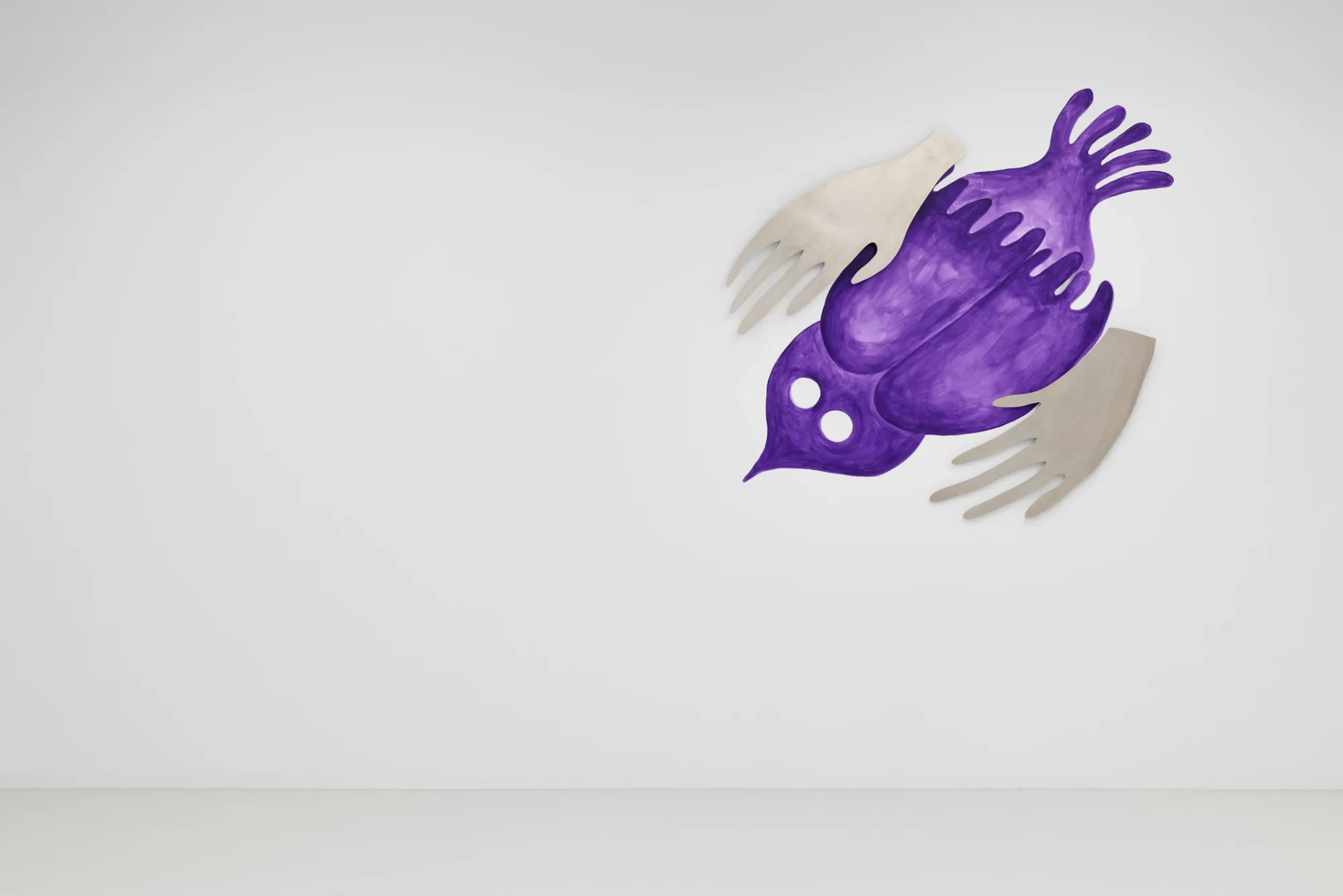Exhibition review of Kallirroi Ioannidou: Galvanizing Memories at Kallmann-Museum, Ismaning, 2026. Close view of the purple bird mural, its wings made from cut sheets of metal shaped like open human hands, with two round holes for eyes.