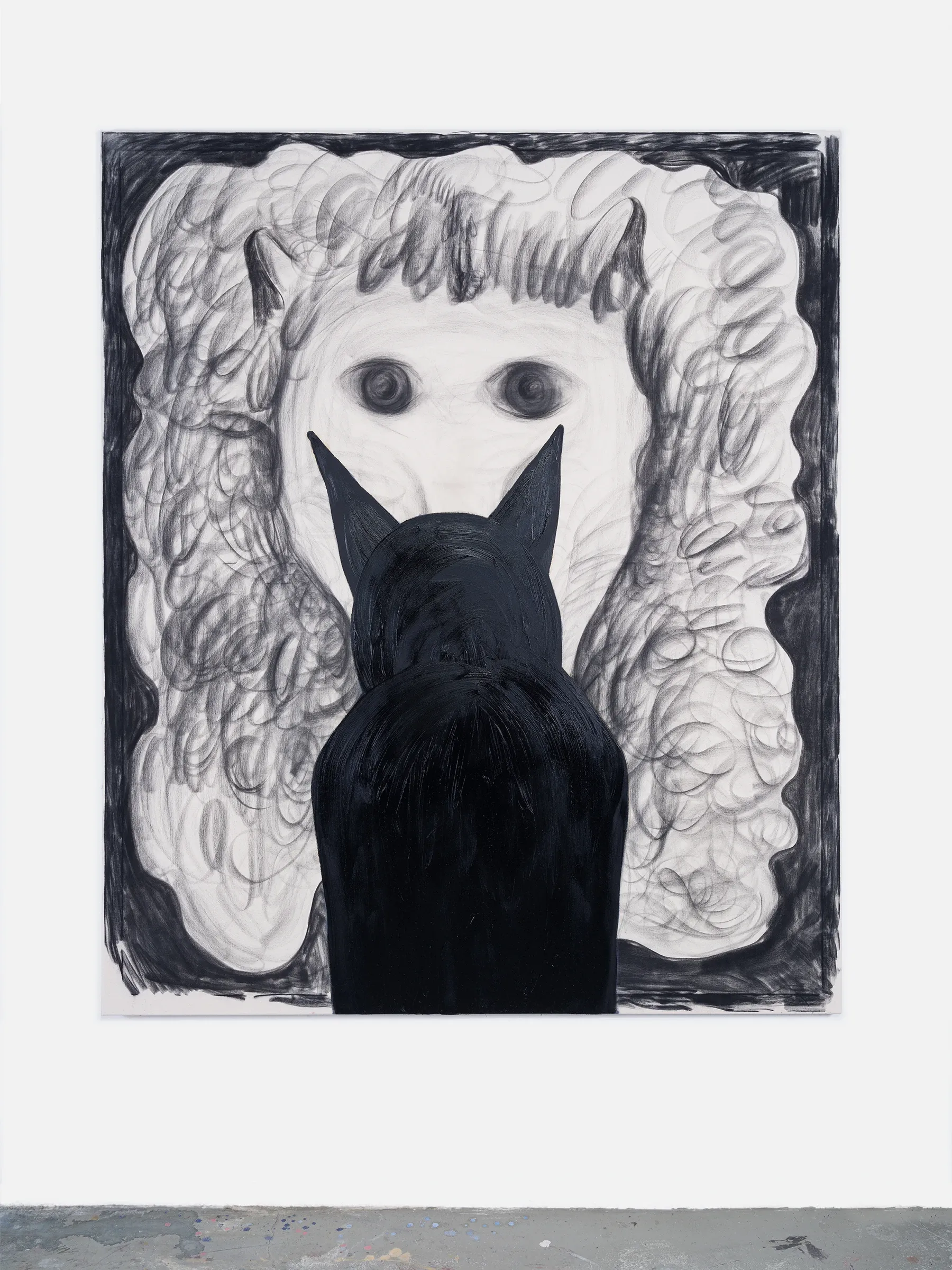 Exhibition review of Kallirroi Ioannidou: Galvanizing Memories at Kallmann-Museum, Ismaning, 2026. Charcoal drawing of a pale, textured face with two large dark eyes, partly hidden behind the black silhouette of a cat's back and pointed ears.