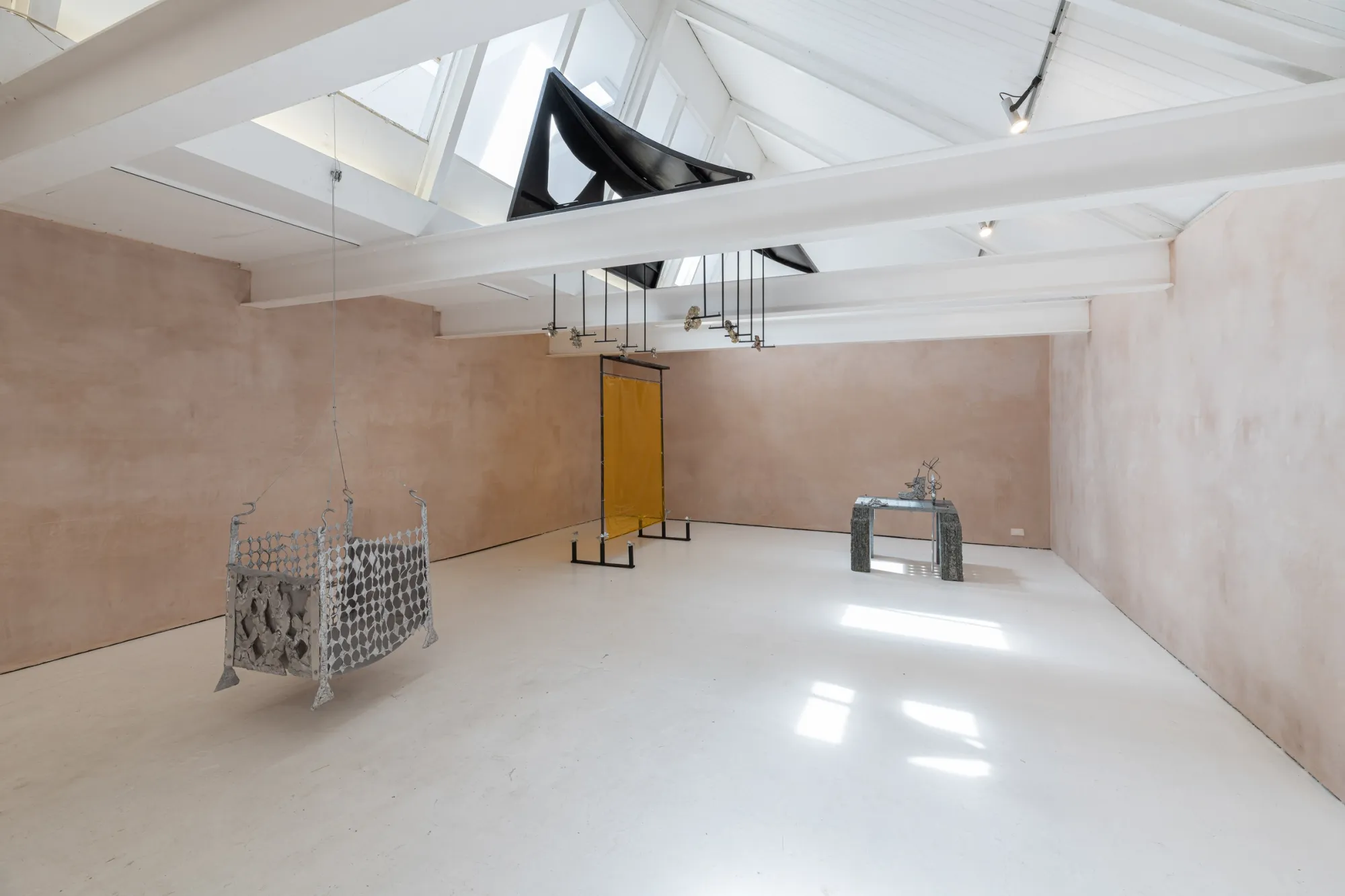 Exhibition review of Maija Fox: As the sap rises at OUTPOST, Norwich, 2026. A diamond-mesh aluminium screen beside a Baltic Green granite table.