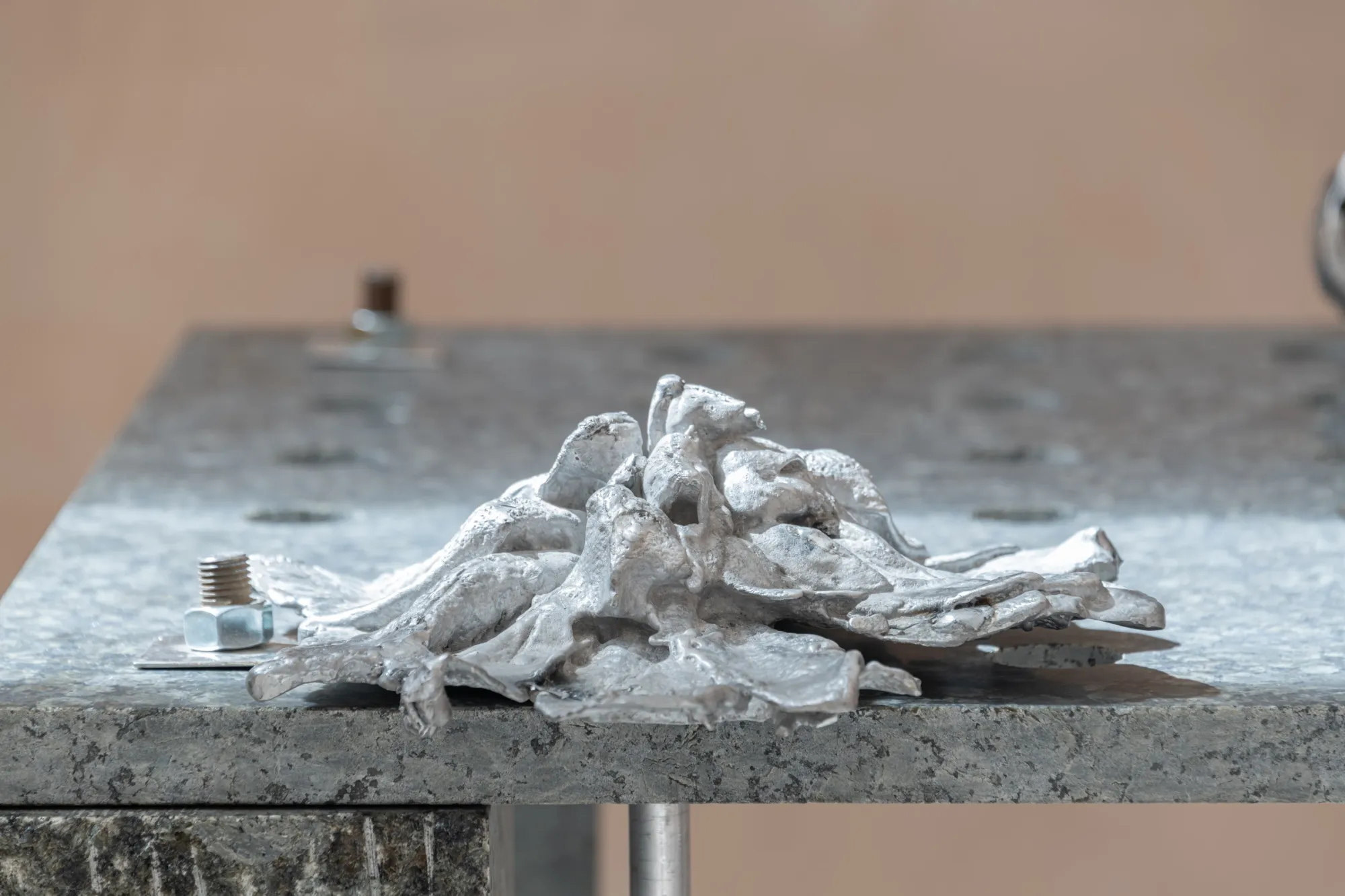 Exhibition review of Maija Fox: As the sap rises at OUTPOST, Norwich, 2026. A pale cast form resembling tangled roots resting on a granite tabletop