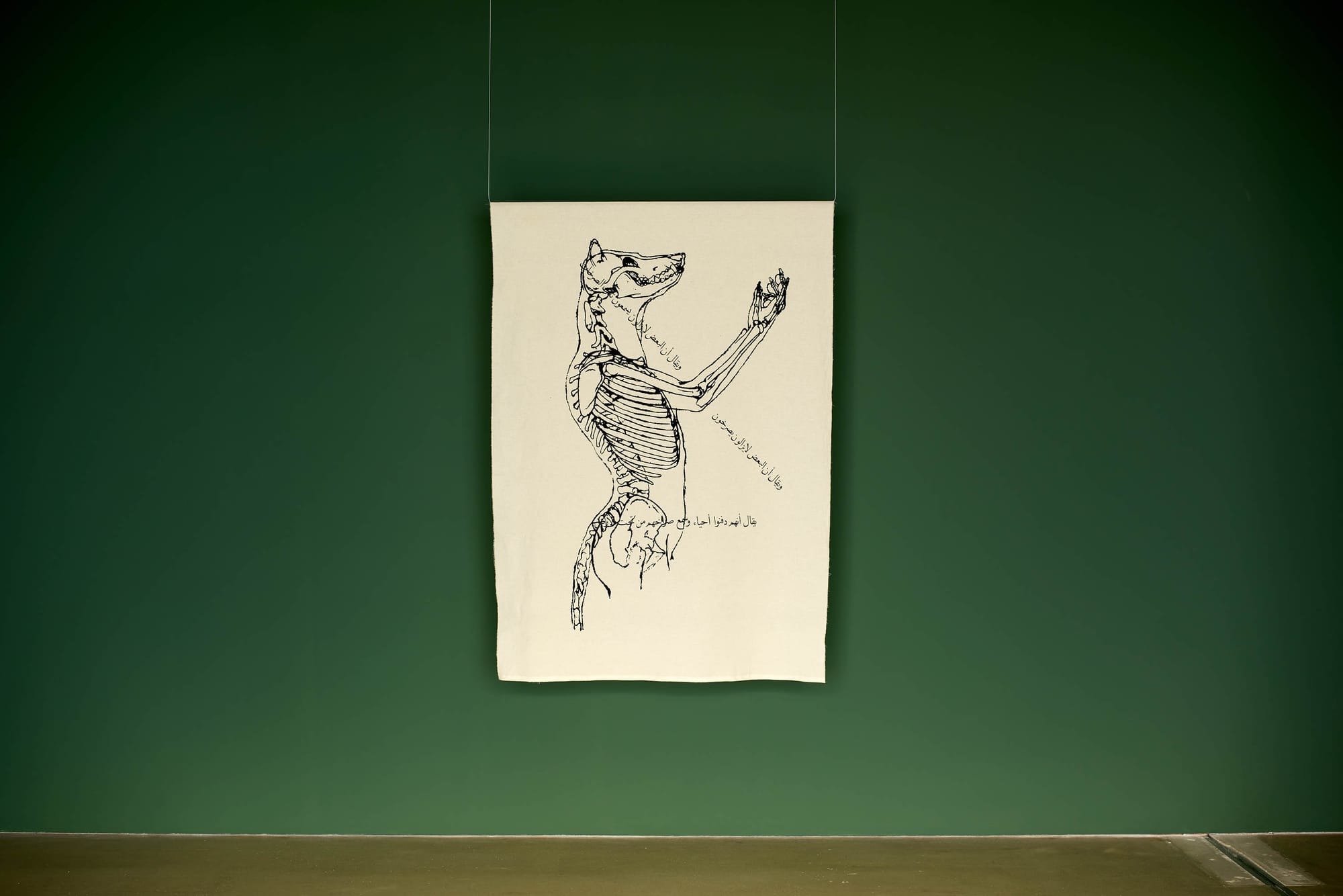 Exhibition review of Marwa Arsanios: Who is Afraid of Ideology? at TAXISPALAIS Kunsthalle Tirol, Innsbruck, 2026. Cream fabric panel with an ink-line drawing of an animal skeleton and Arabic script.