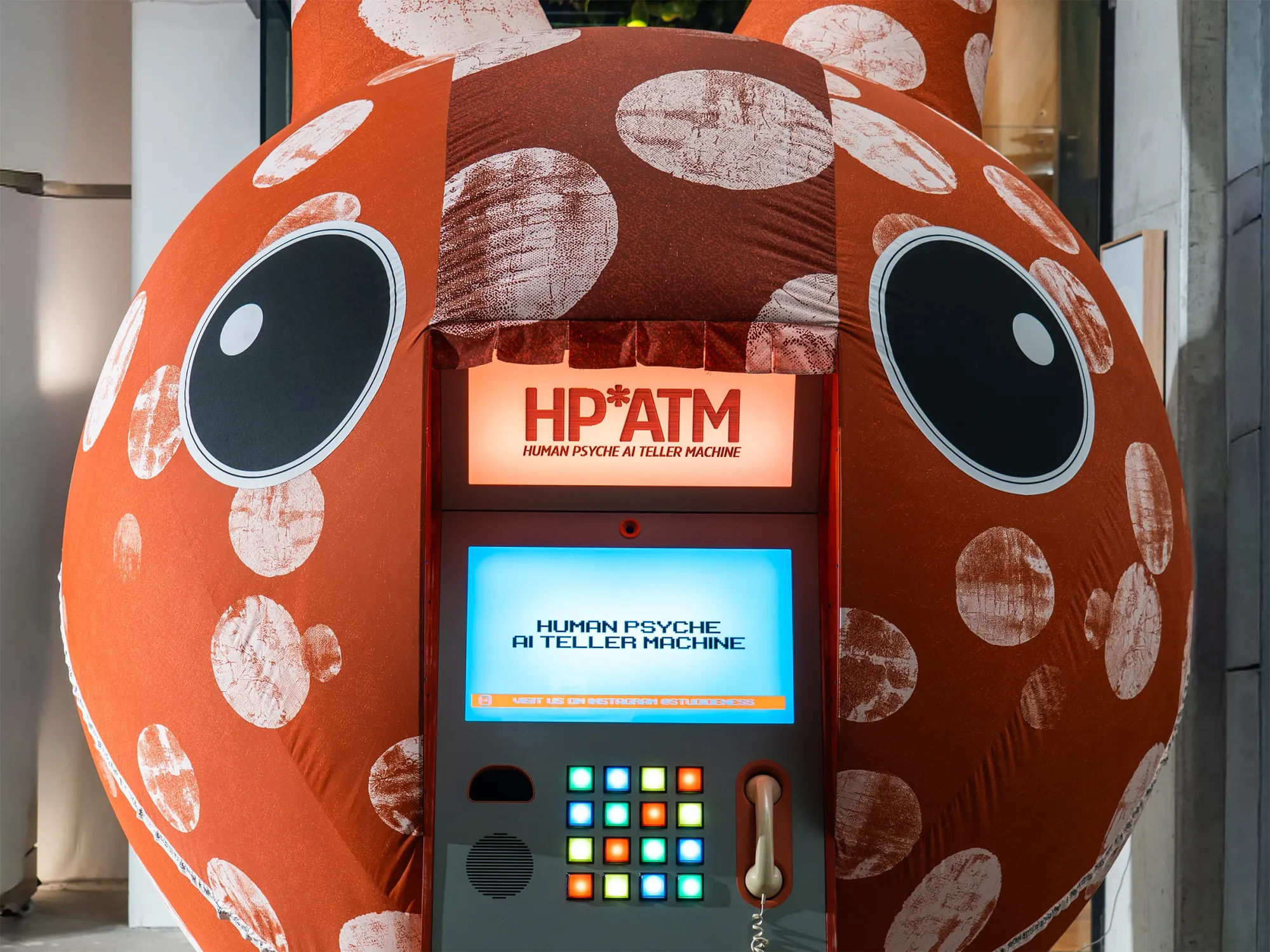 Exhibition review of Nimrod Weis: HPATM at FUTUREJUICE, Adelaide, 2026. Close-up of the sculpture's black cartoon eyes framing the lit sign.
