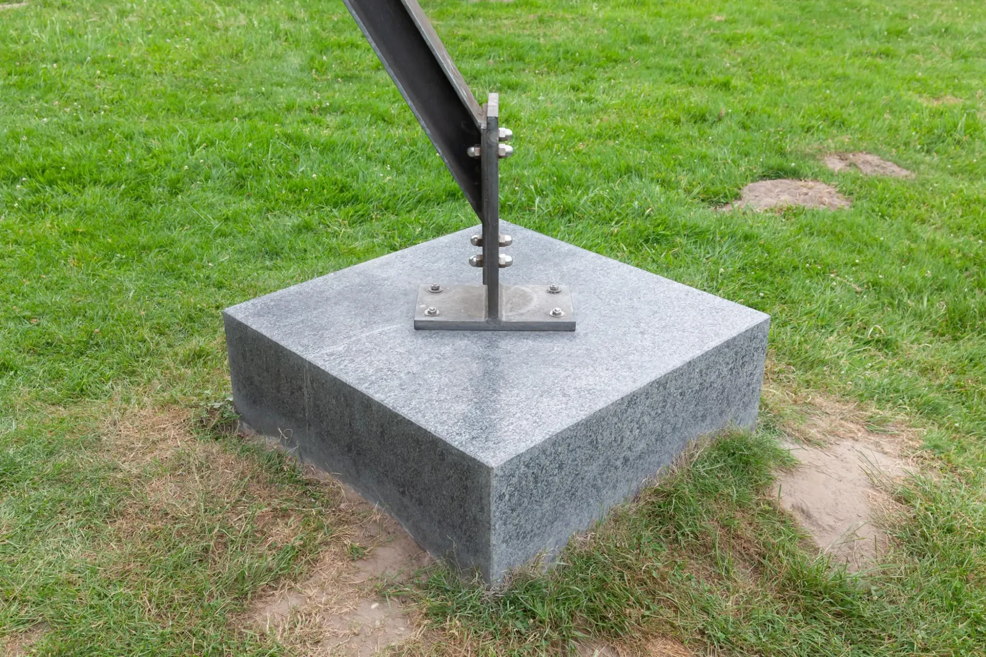 Reparaturgesellschaft, Wewerka Pavilion, Münster, 2026, detail of black steel beam bolted to granite plinth on grass