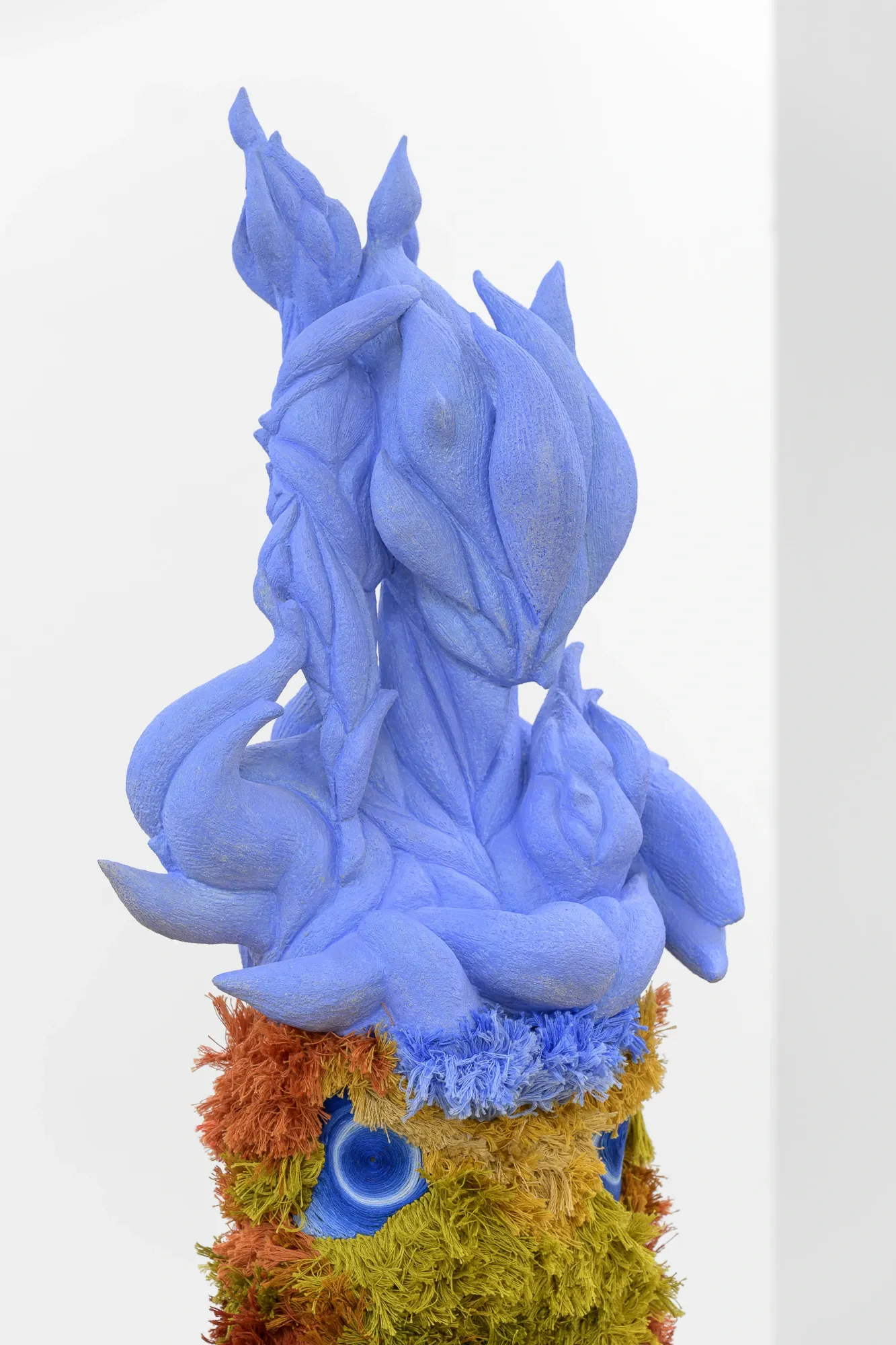 Exhibition review of Soft Power: close-up detail of pale blue fibrous sculpture crown with moss at its base.