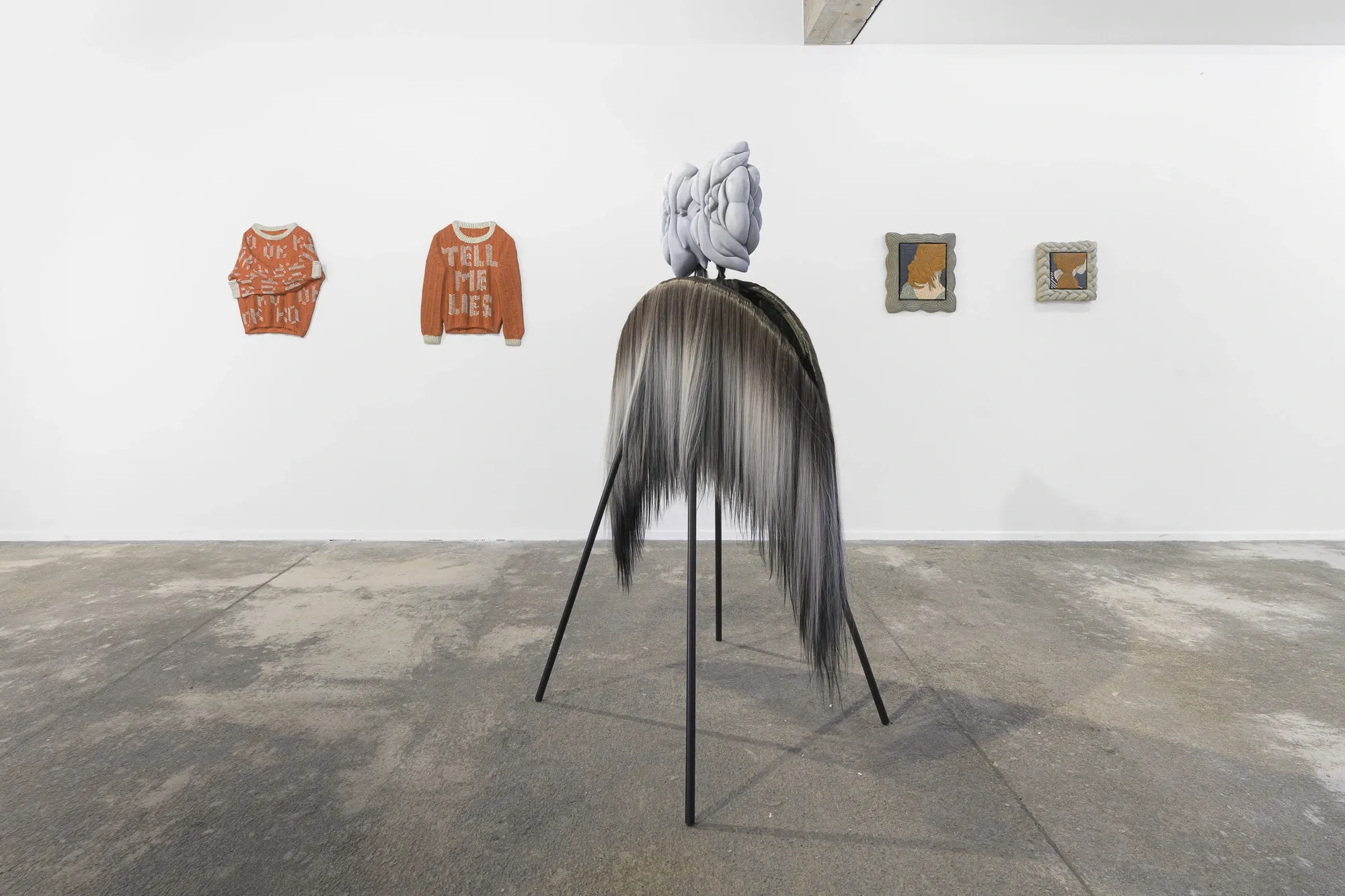 Exhibition review of Soft Power: concrete sweater reliefs, painting and sculpture grouped on gallery wall, Umrian Gallery, Bratislava, 2026.
