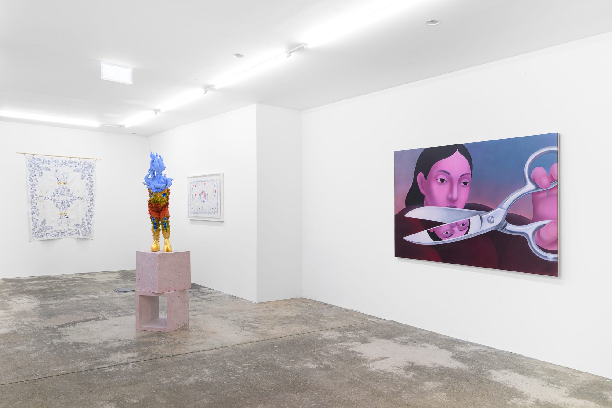 Exhibition review of Soft Power: gallery room seen at a distance with sculpture, framed embroidery and painting on white walls.