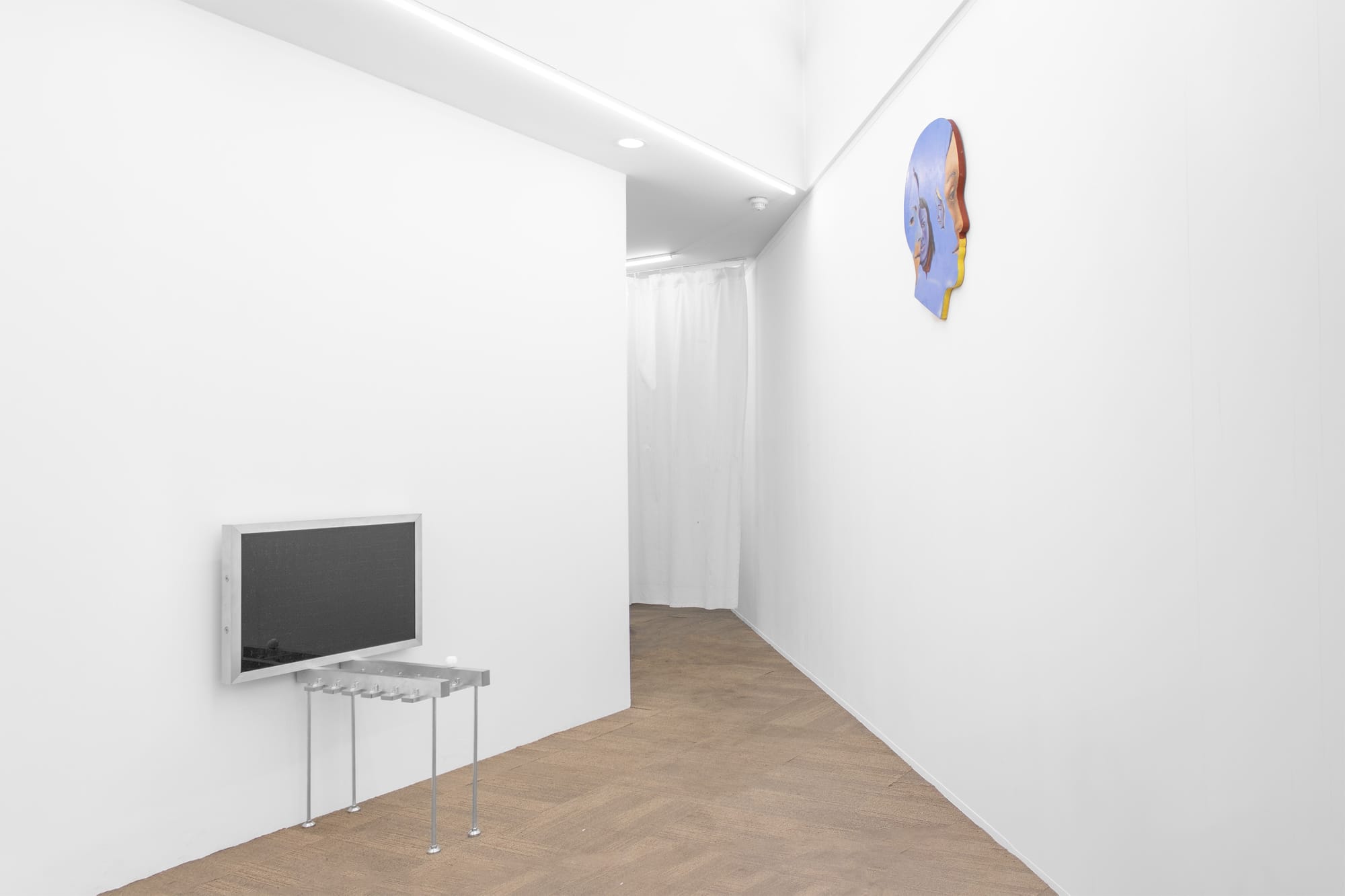 Emergency Space, Paris, 2026. Corridor view with a wall-mounted metal panel and a painted wood head profile in the distance