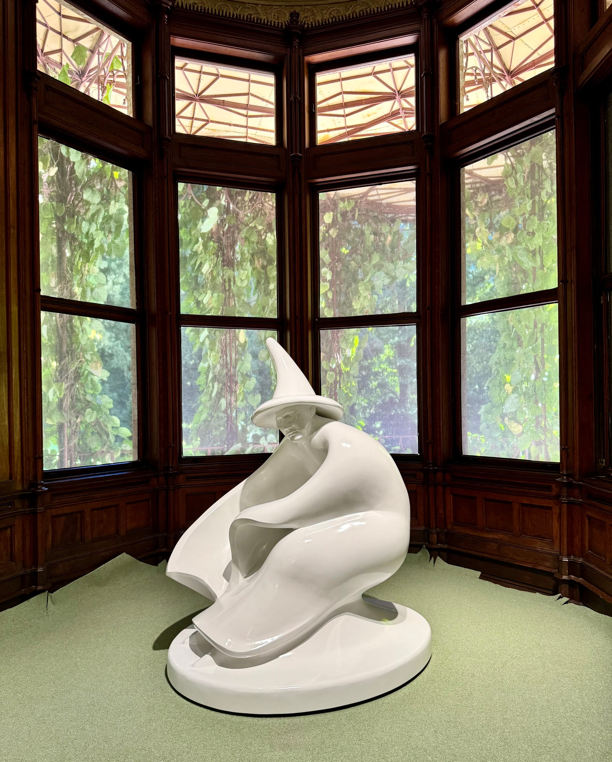 Jakob Lena Knebl’s Die Schwebende, a white seated figure before tall wooden windows at the Marmorschlössl.