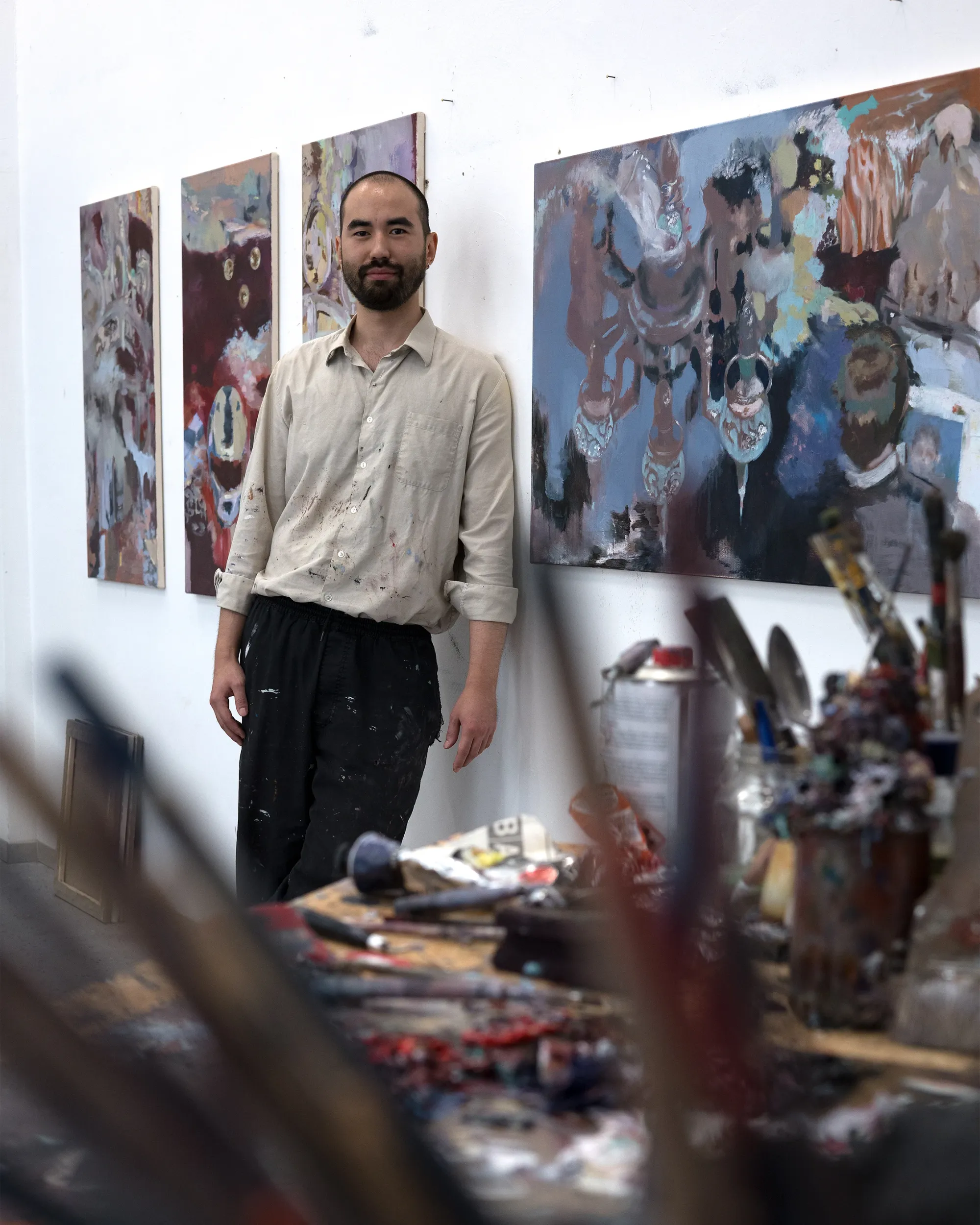Parallel Vienna 2026 - Artist Profile Feature: Baurjan Aralov, painted canvases leaning against a studio wall with brushes and a work table.