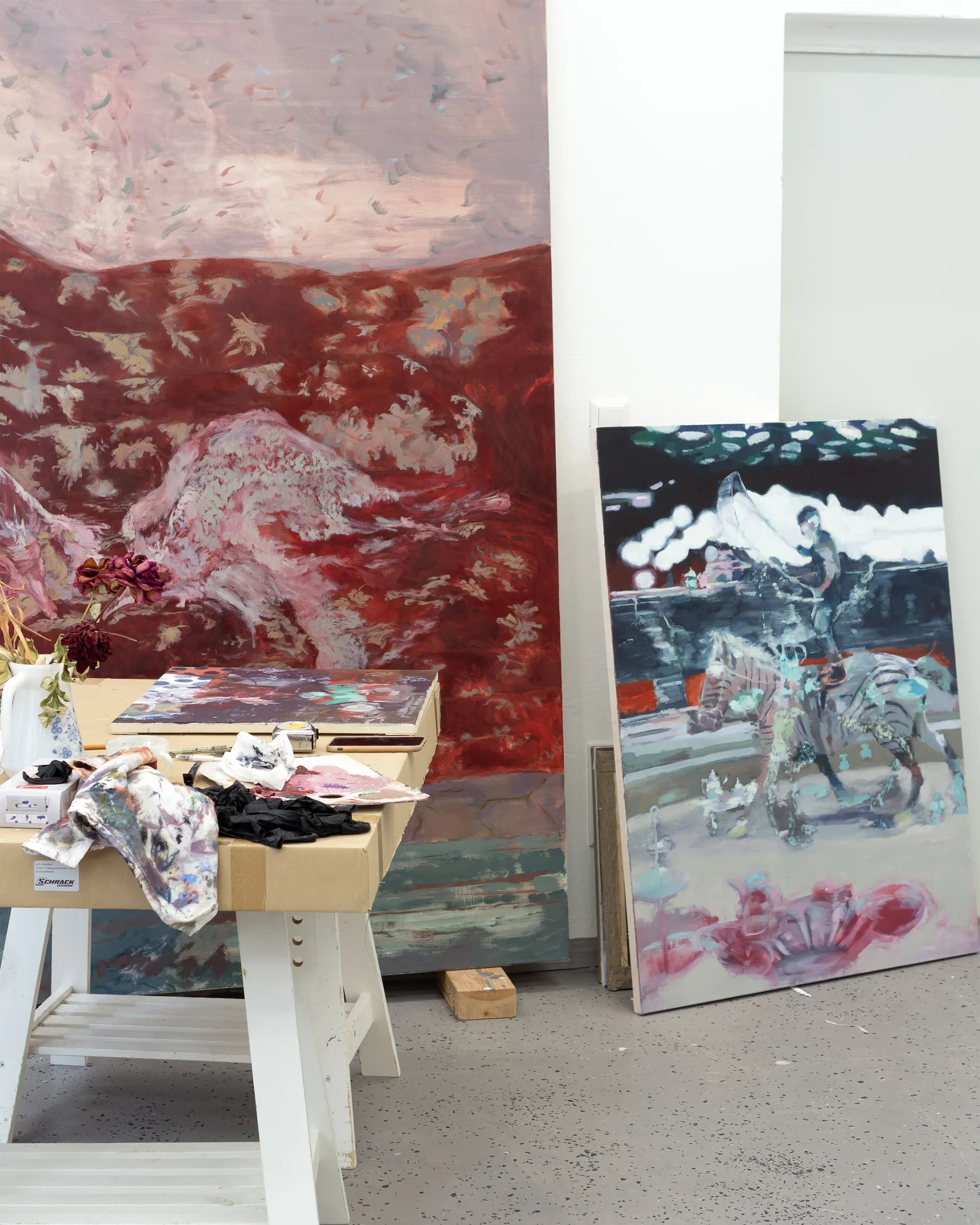 Parallel Vienna - Baurjan Aralov, painted canvases leaning against a studio wall with brushes and a work table, catapult contemporary