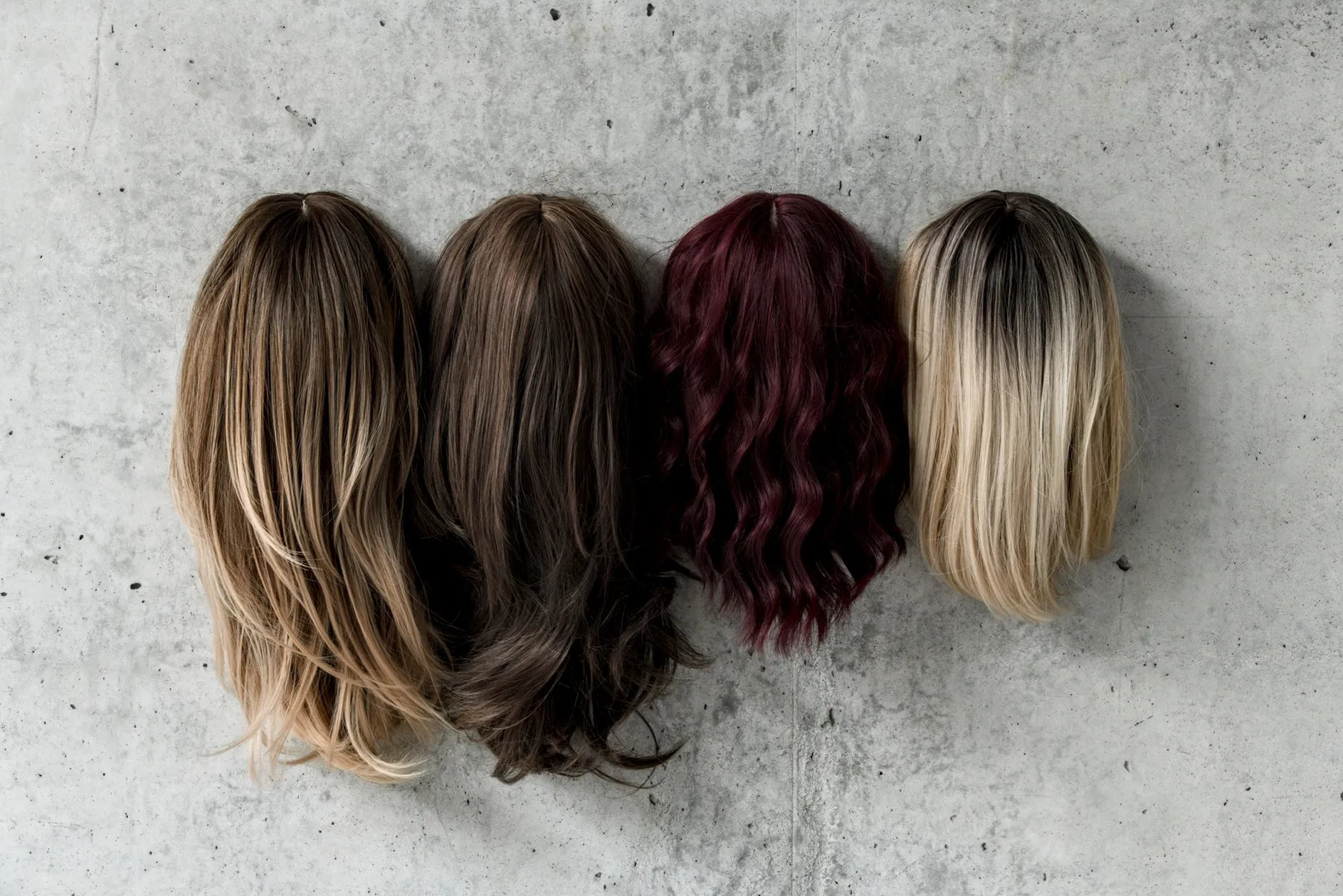 Exhibition review of I Think My Body No Longer Belongs to Me at roam projects e. V., Berlin, 2026. Four wigs, blonde, brown, wine red, hung in a row.