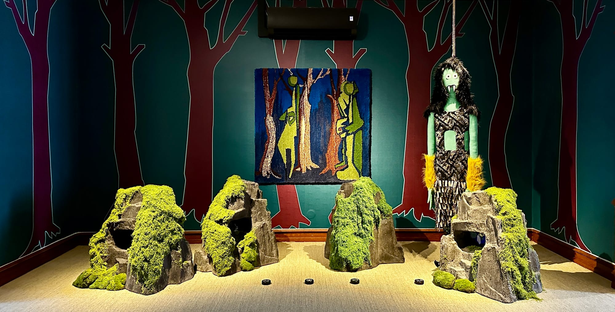 Jakob Lena Knebl installation with moss-covered forms and a suspended green figure at the Marmorschlössl.